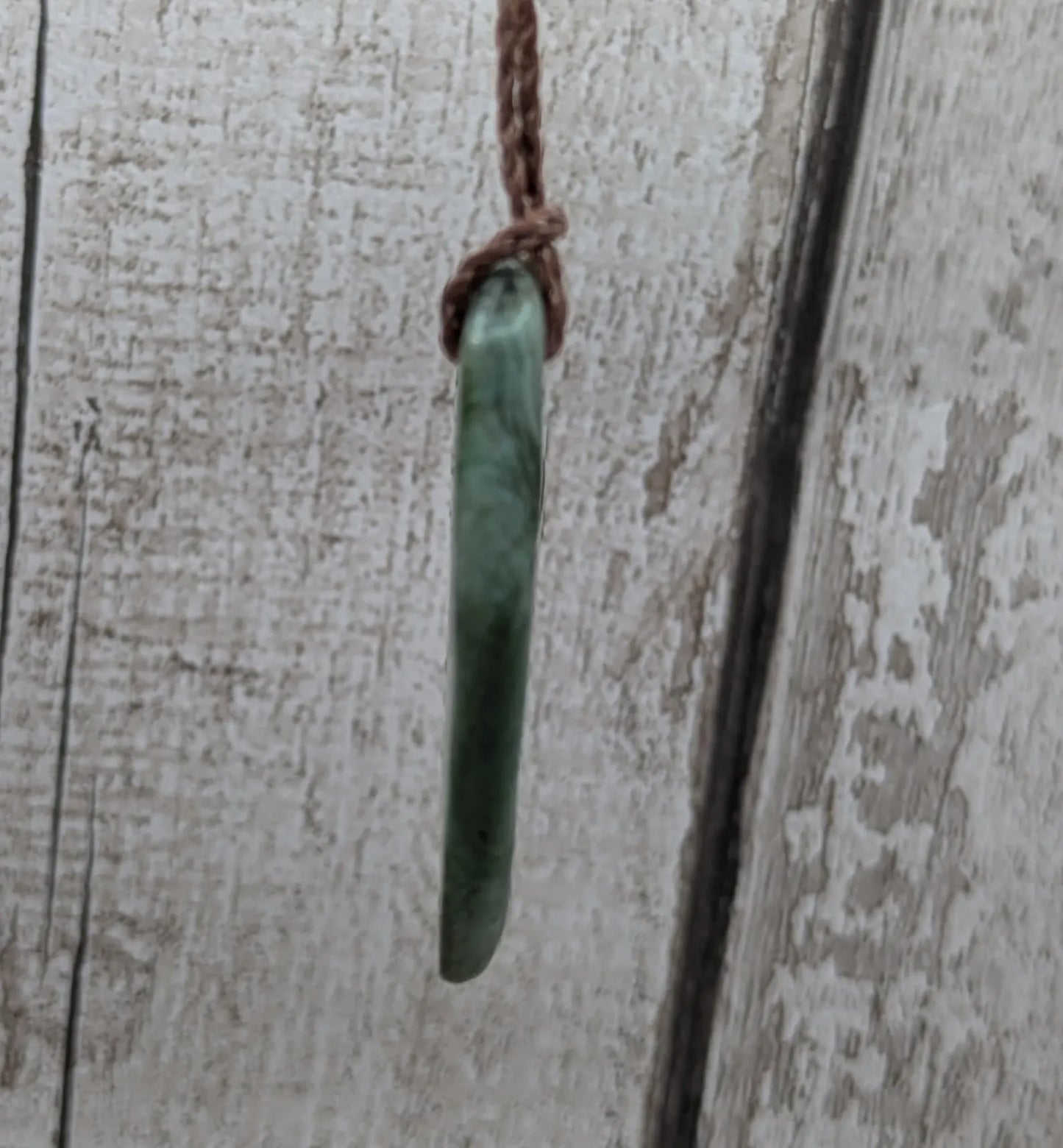 Chatoyant New Zealand tumbled Pounamu greenstone pendant.