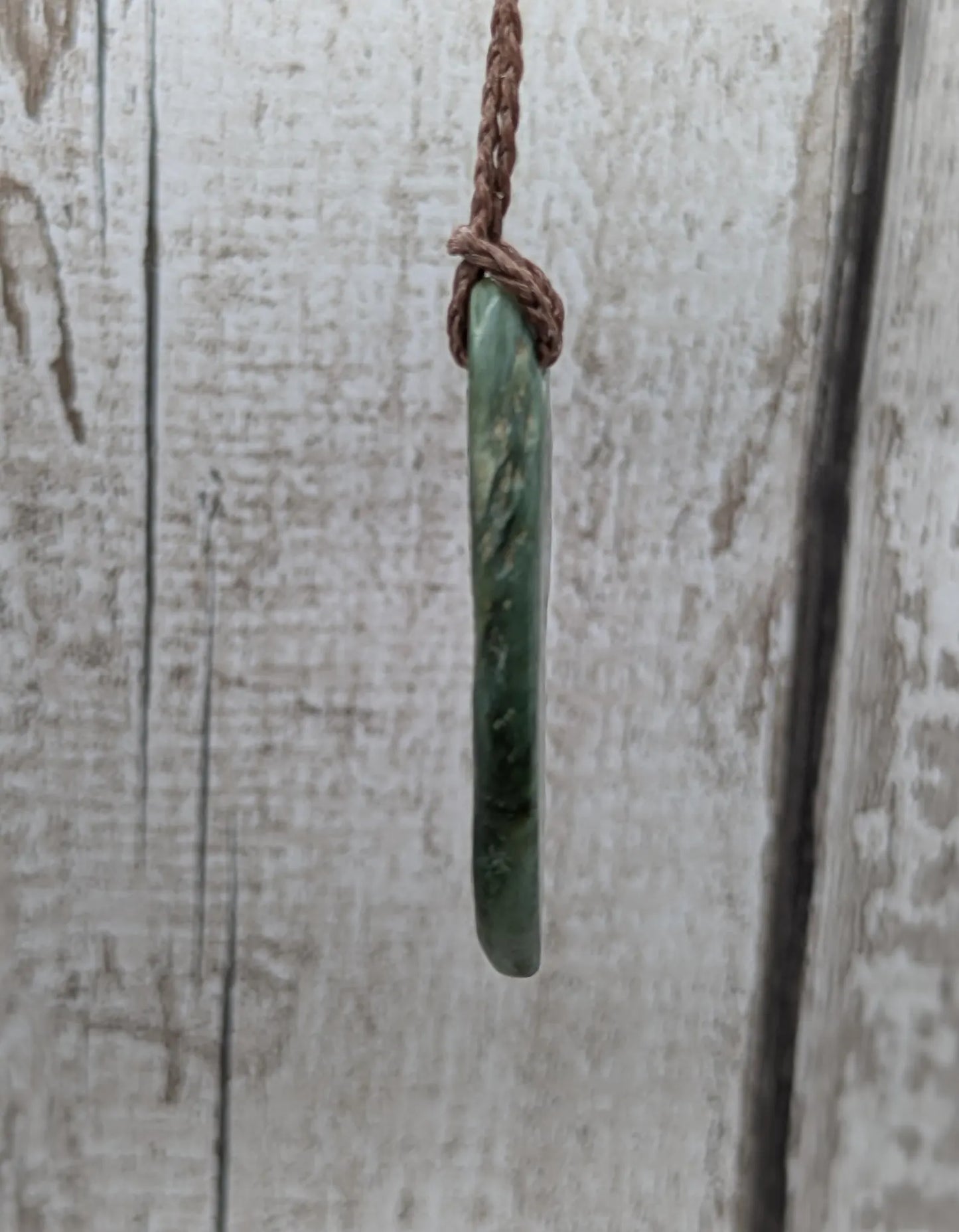 Chatoyant New Zealand tumbled Pounamu greenstone pendant.