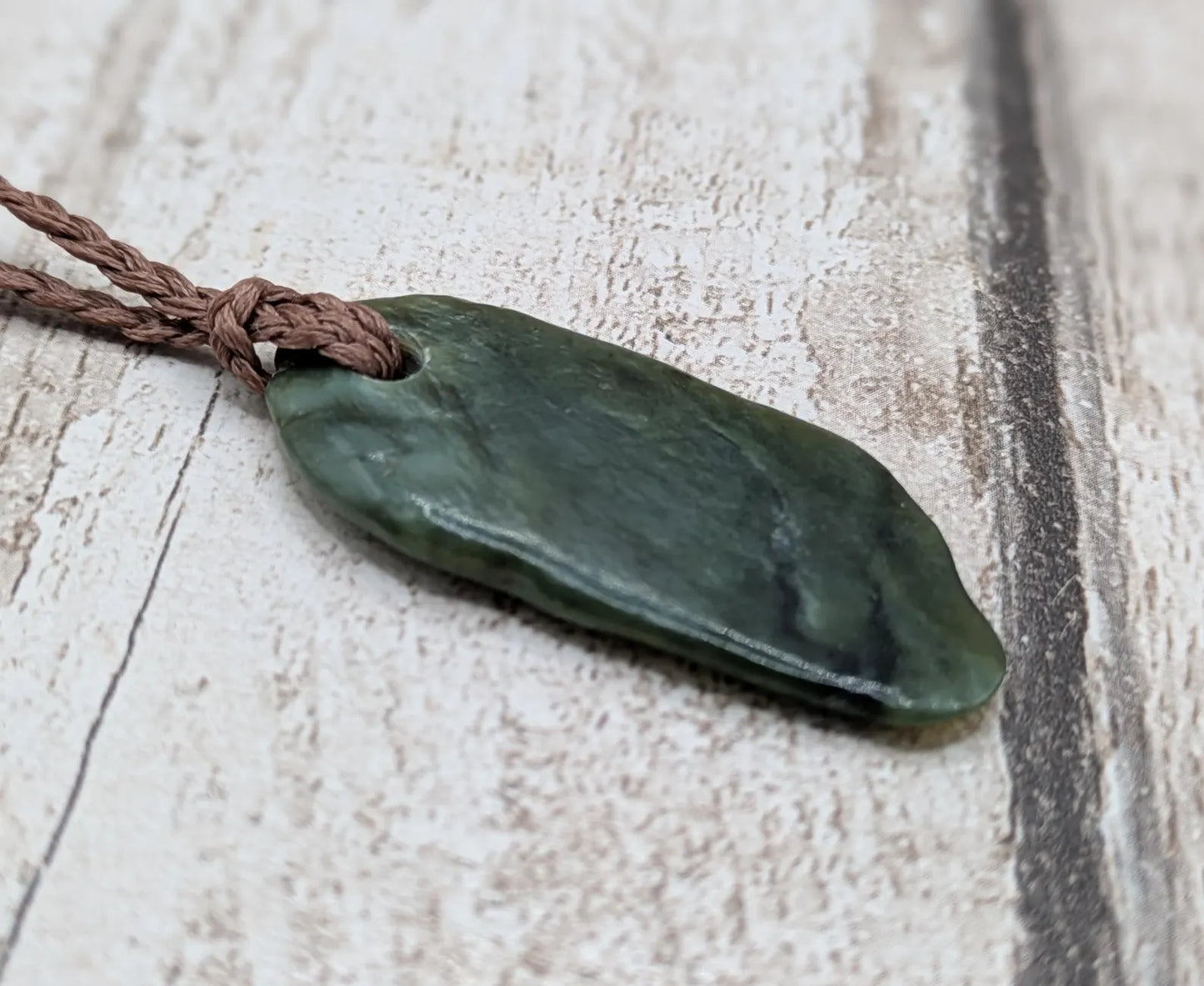 Tumbled Pounamu greenstone nephrite jade pendant.