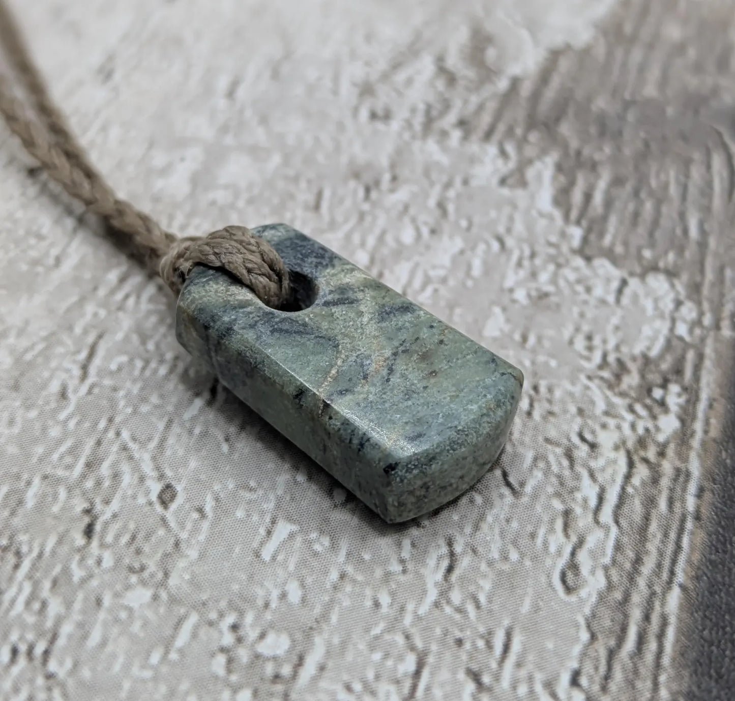 Tiny New Zealand greenstone jade roimata pendant.