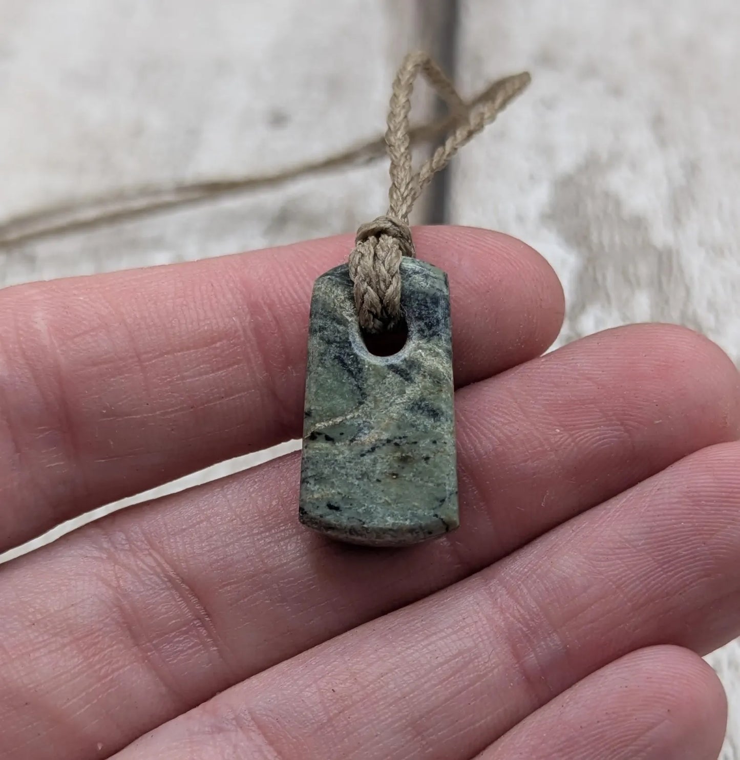 Tiny New Zealand greenstone jade roimata pendant.