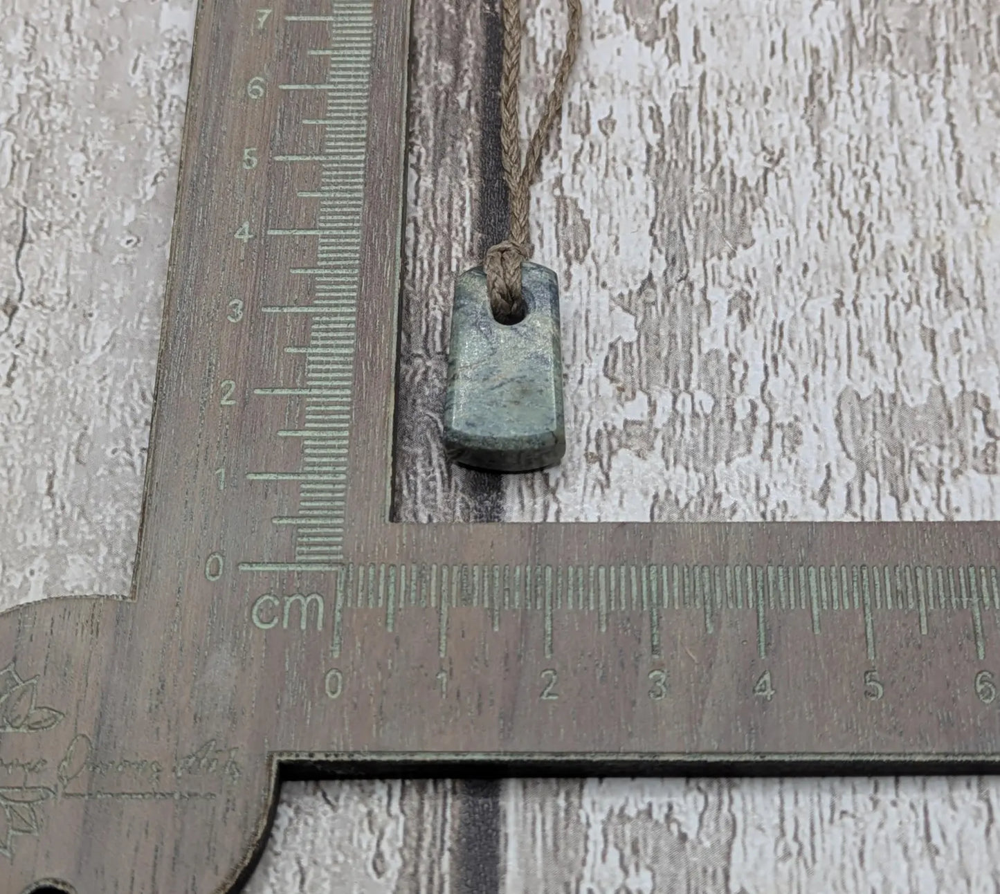 Tiny New Zealand greenstone jade roimata pendant.