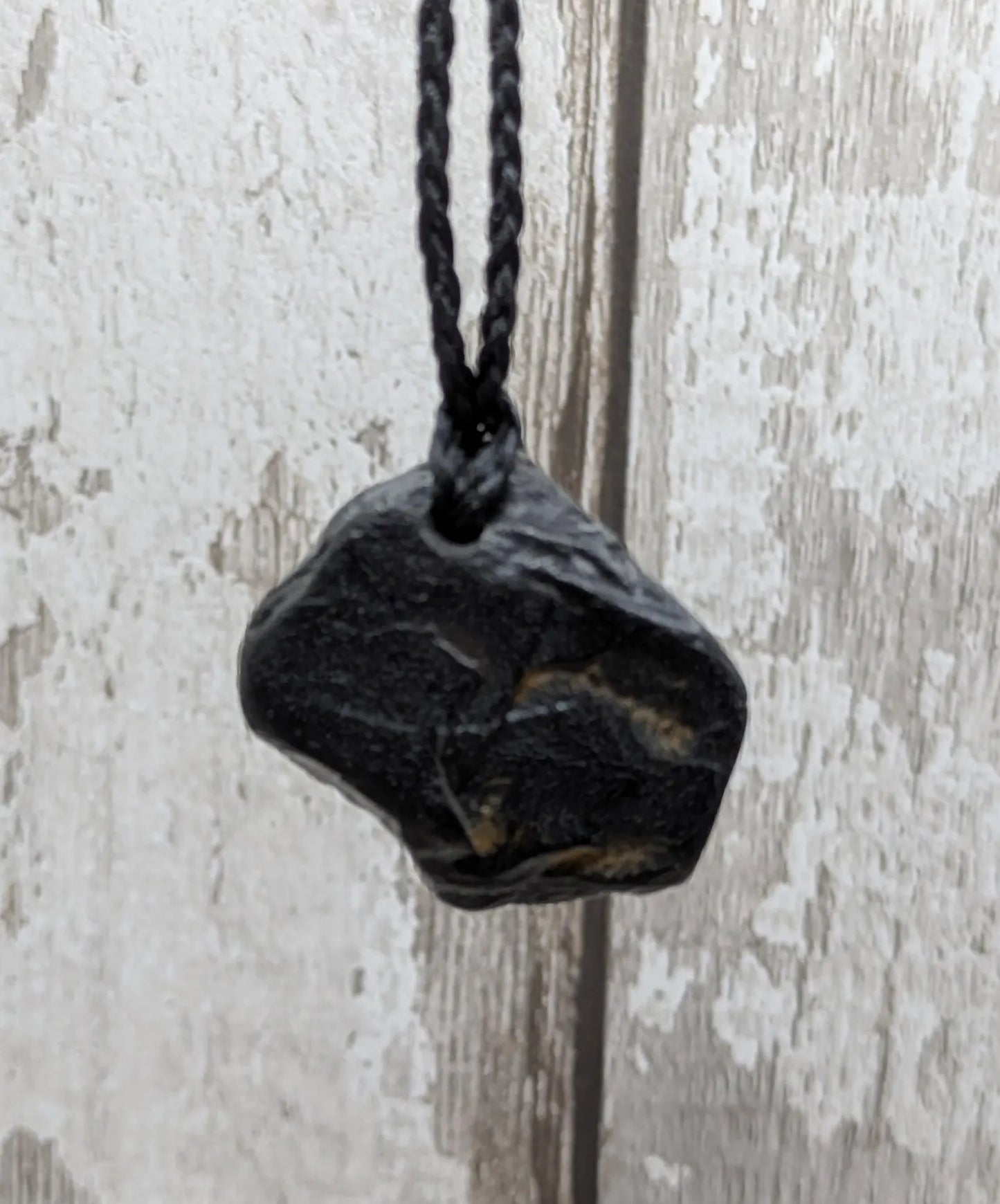 Raw naturally tumbled Whitby jet simple pendant.