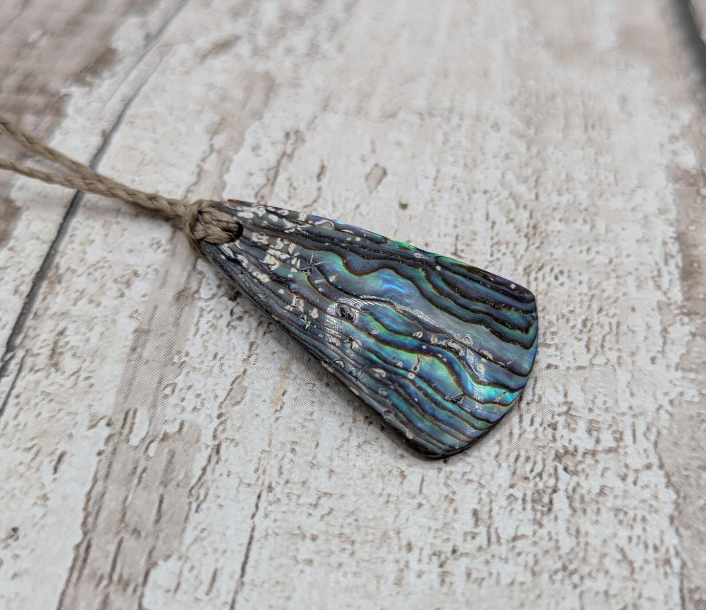 Small New Zealand Pāua Shell Triangle Pendant – Iridescent Abalone Necklace on Adjustable Waxed Cord, ocean themed, natural pattern.