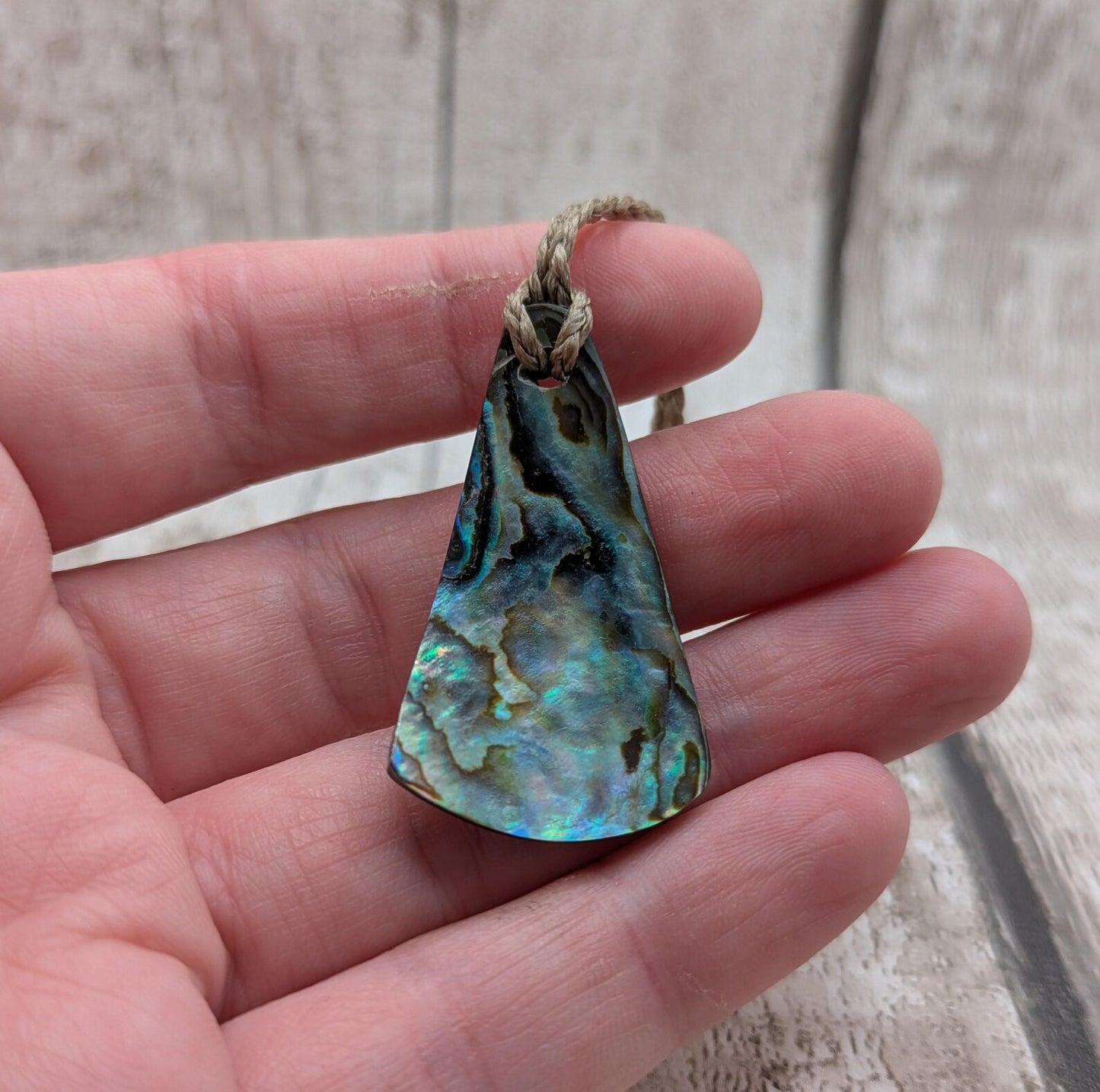 Small New Zealand Pāua Shell Triangle Pendant – Iridescent Abalone Necklace on Adjustable Waxed Cord, ocean themed, natural pattern.