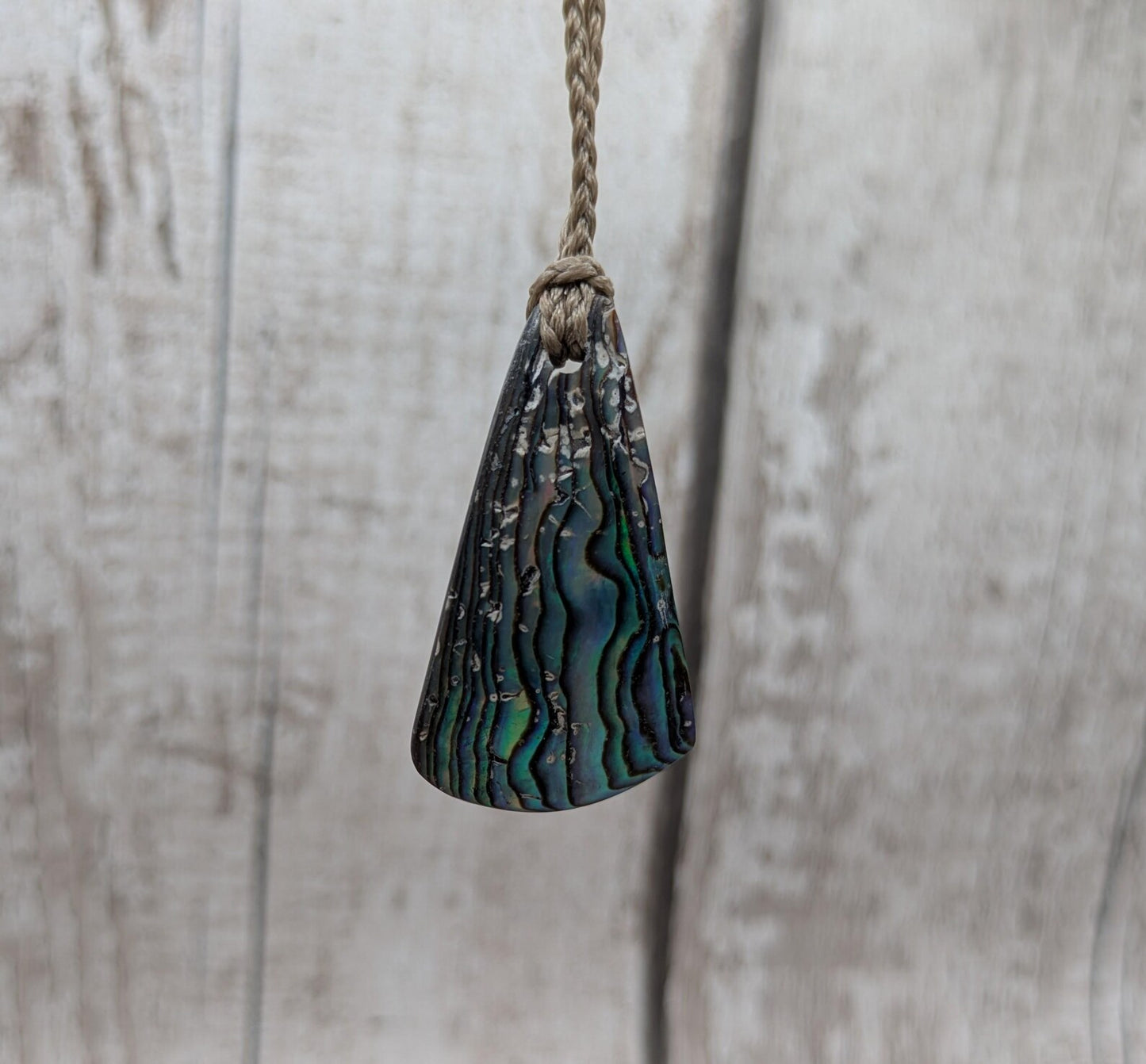 Small New Zealand Pāua Shell Triangle Pendant – Iridescent Abalone Necklace on Adjustable Waxed Cord, ocean themed, natural pattern.