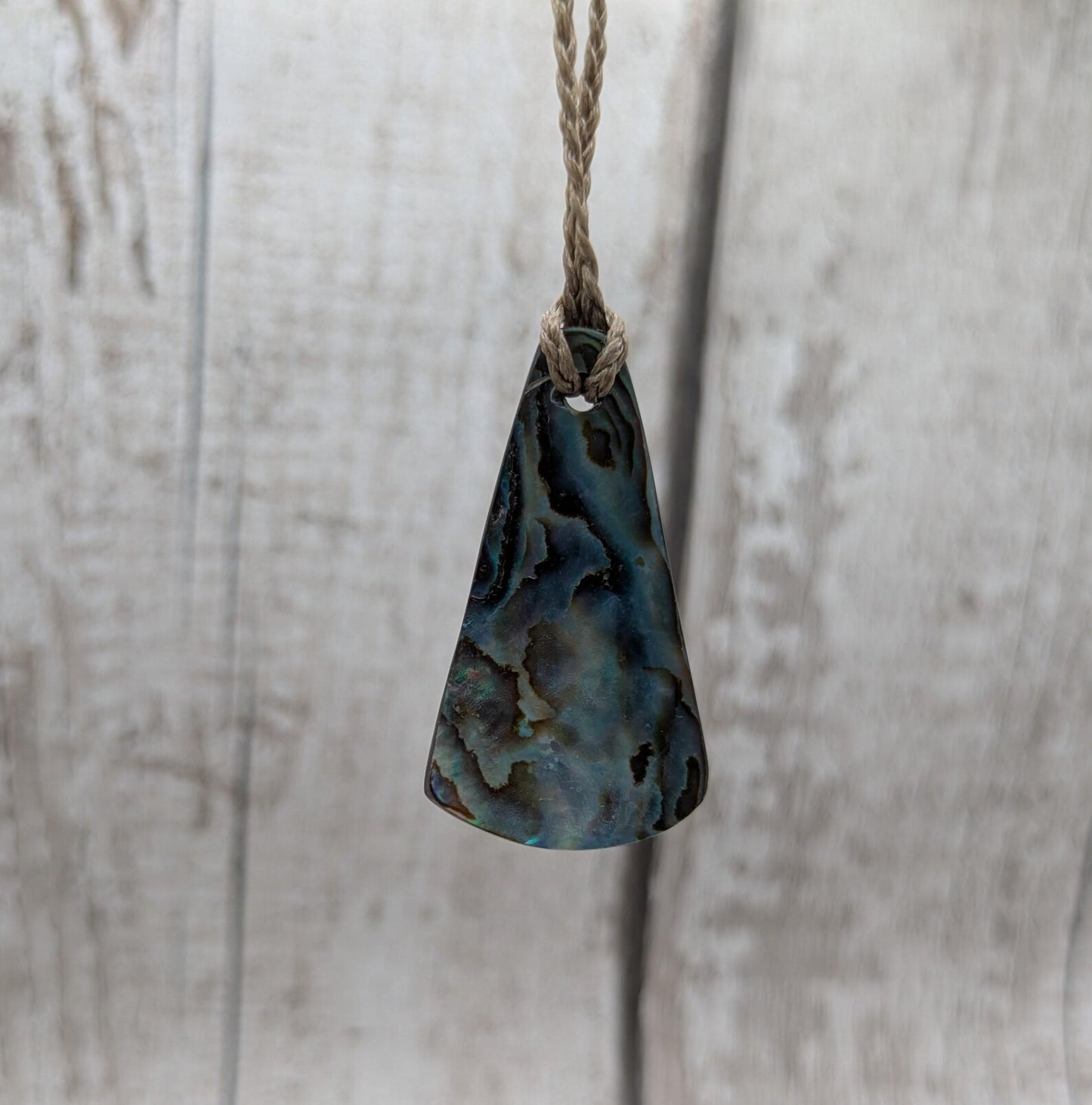 Small New Zealand Pāua Shell Triangle Pendant – Iridescent Abalone Necklace on Adjustable Waxed Cord, ocean themed, natural pattern.