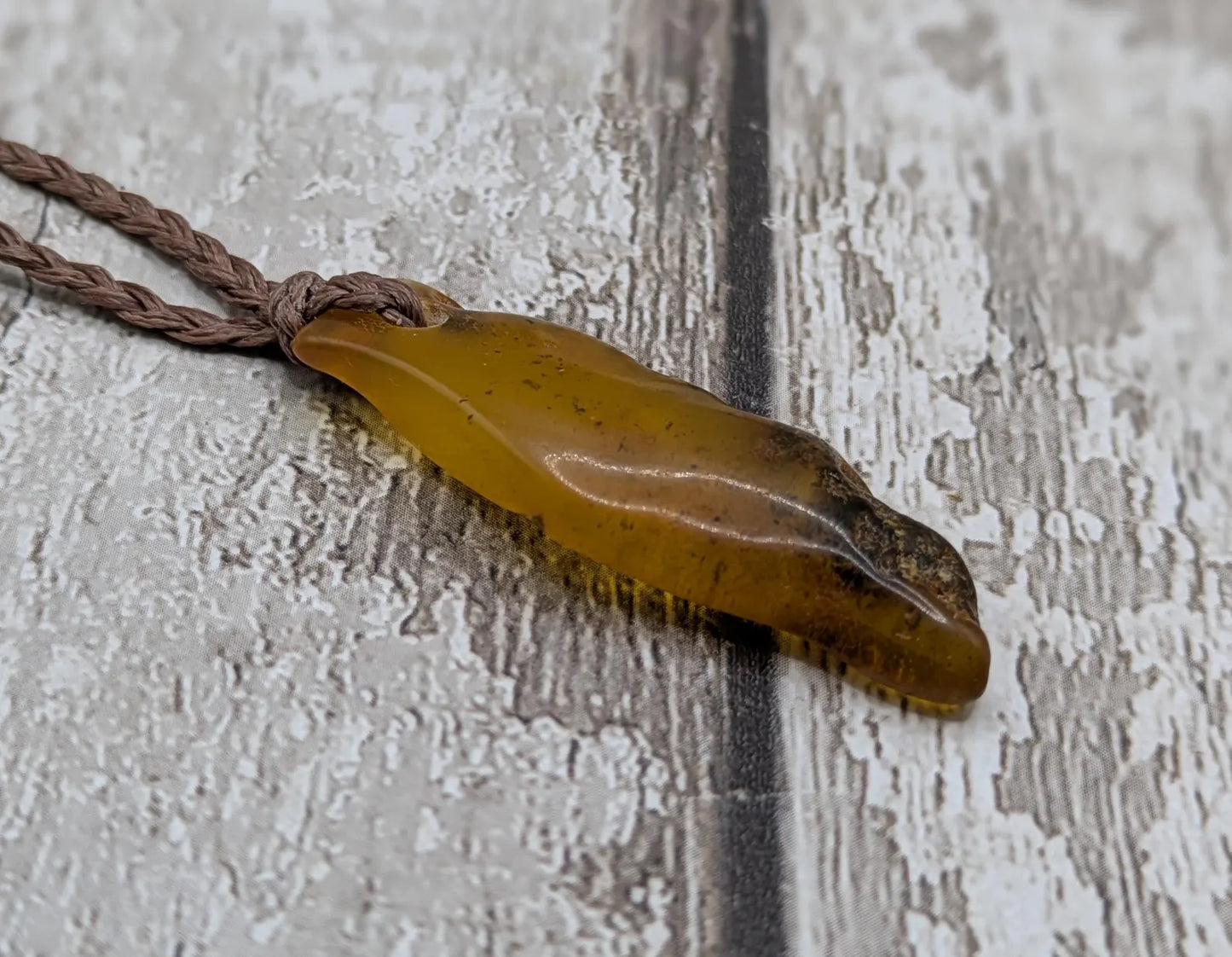 Baltic Amber tumble polished pendant with moss inclusions.