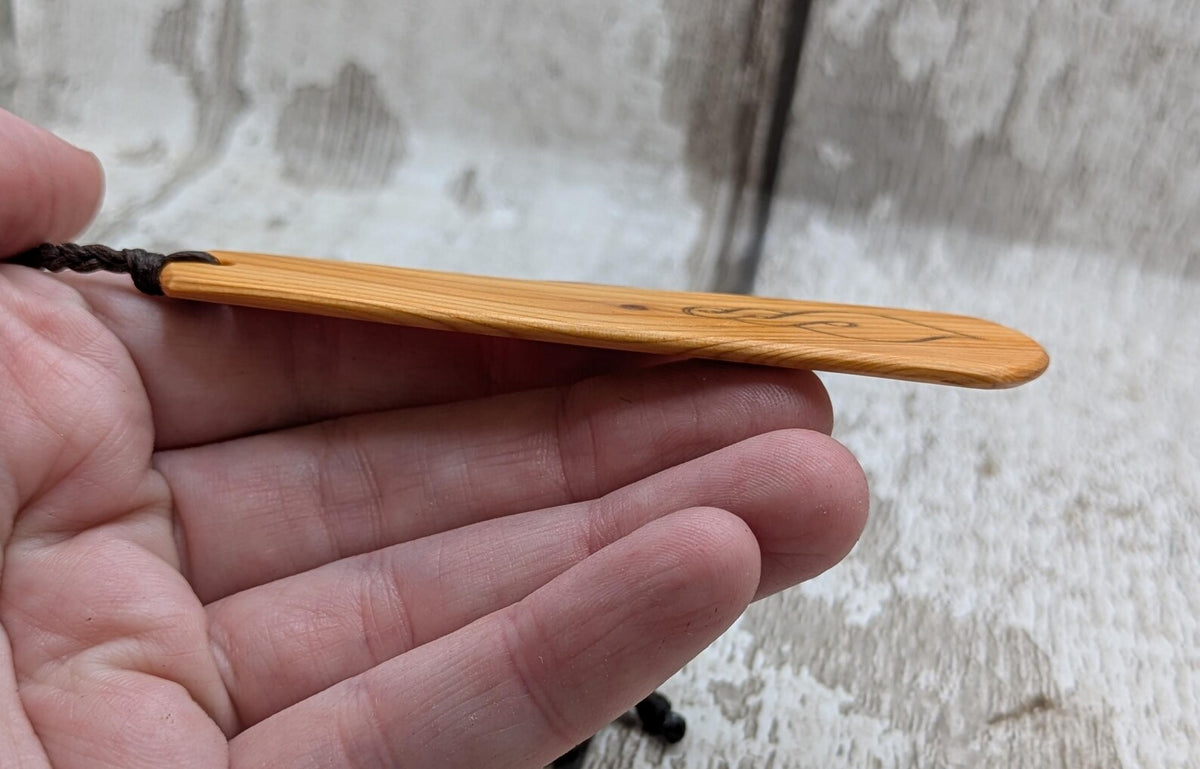 Yew wood pikorua laser printed bookmark with pāua abalone bead tassel.