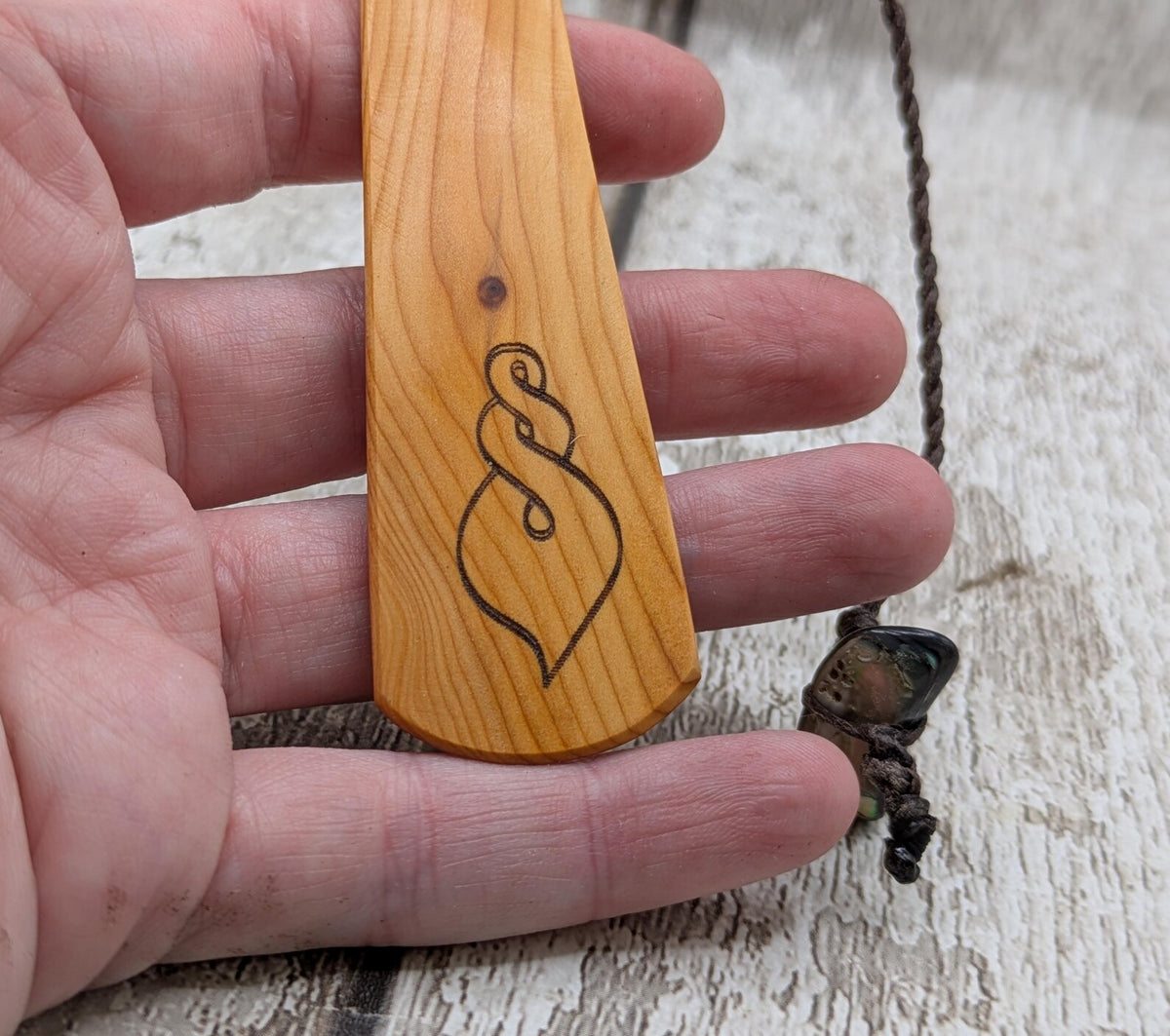 Yew wood pikorua laser printed bookmark with pāua abalone bead tassel.