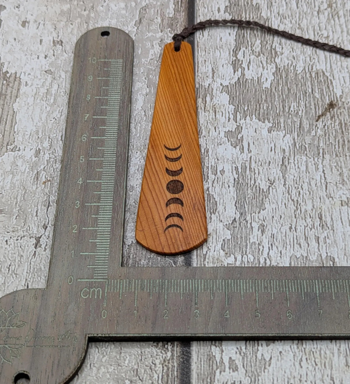 Yew wood with moon phrase laser print and abalone pāua shell bead tassel.