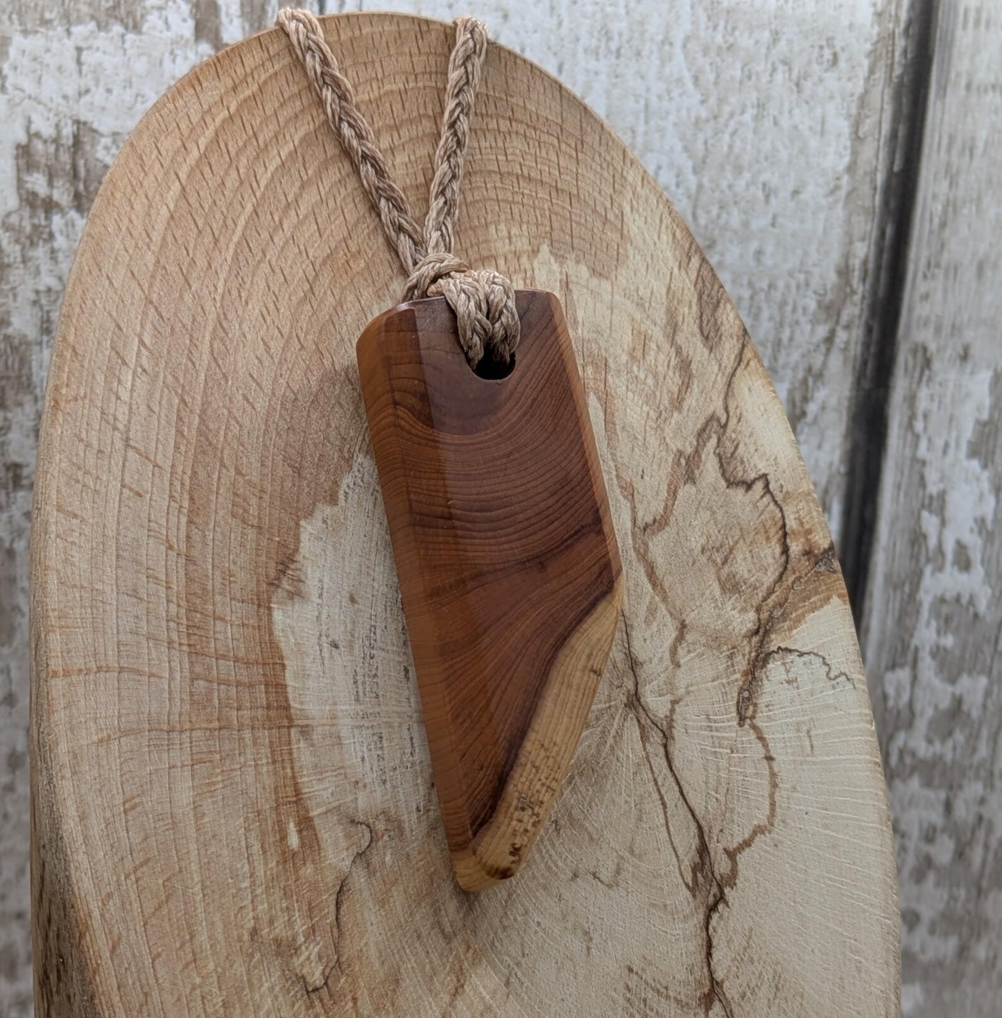 Faceted yew wood slice pendant.