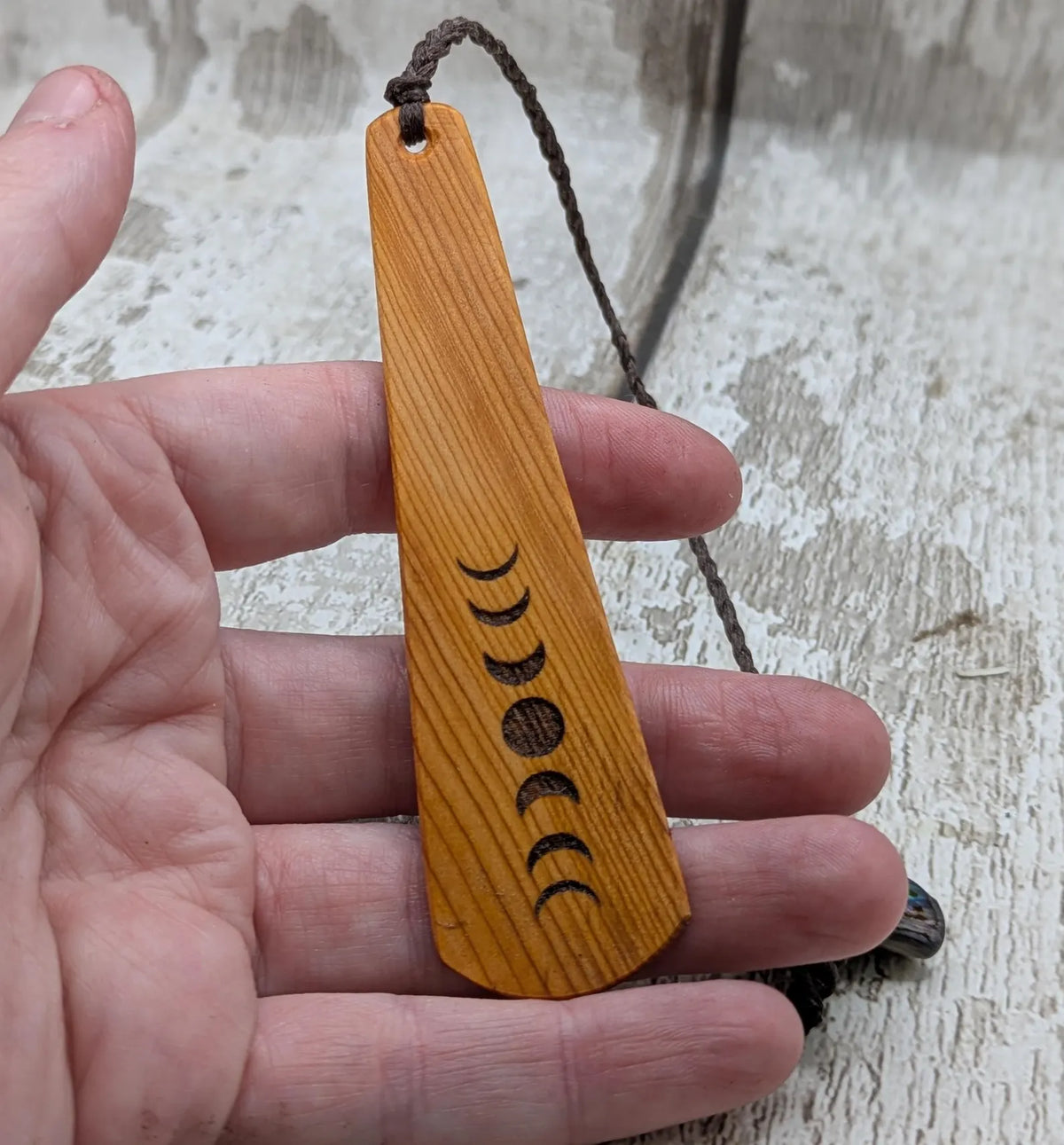 Yew wood with moon phrase laser print and abalone pāua shell bead tassel.