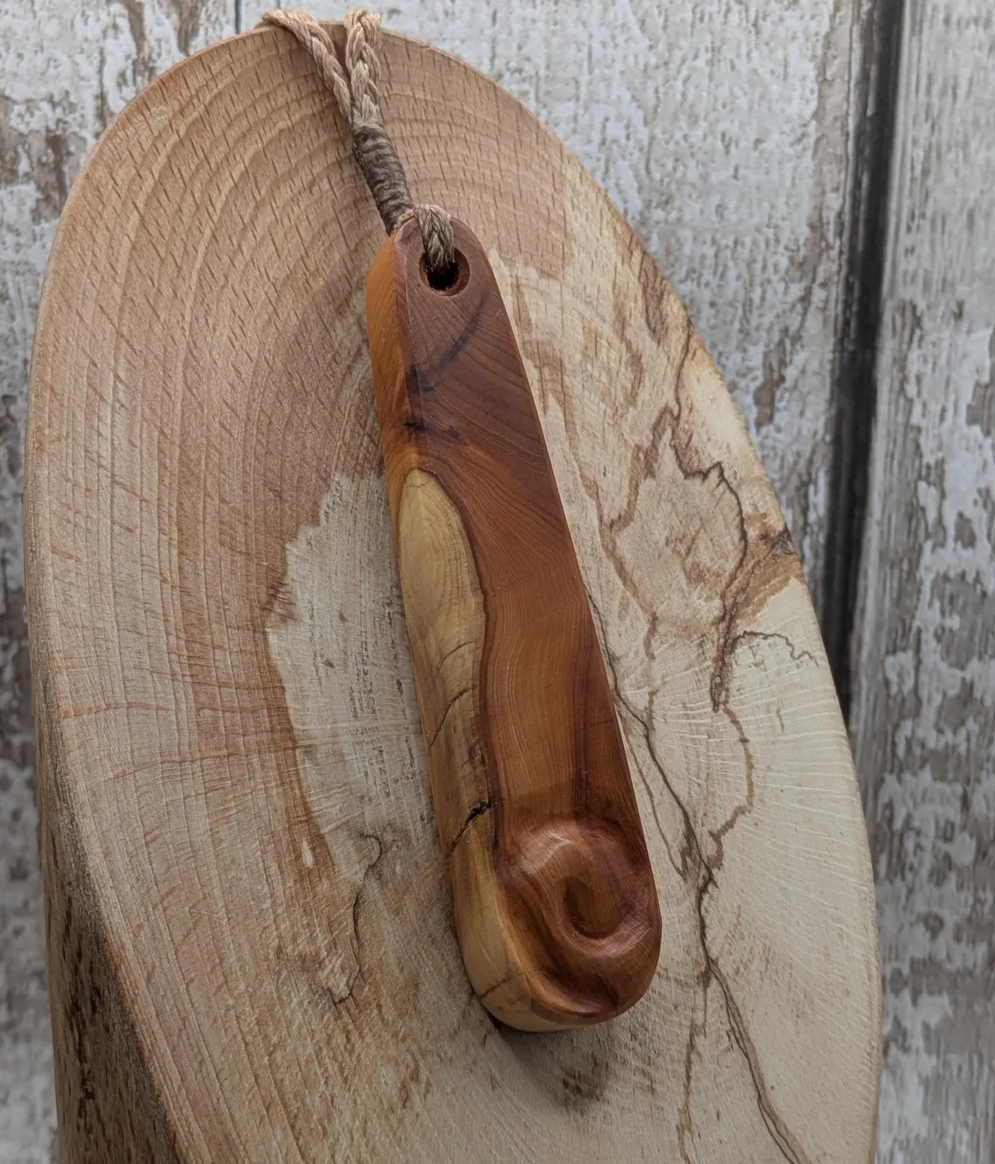 Yew wood roimata teardrop pendant with Koru spiral.