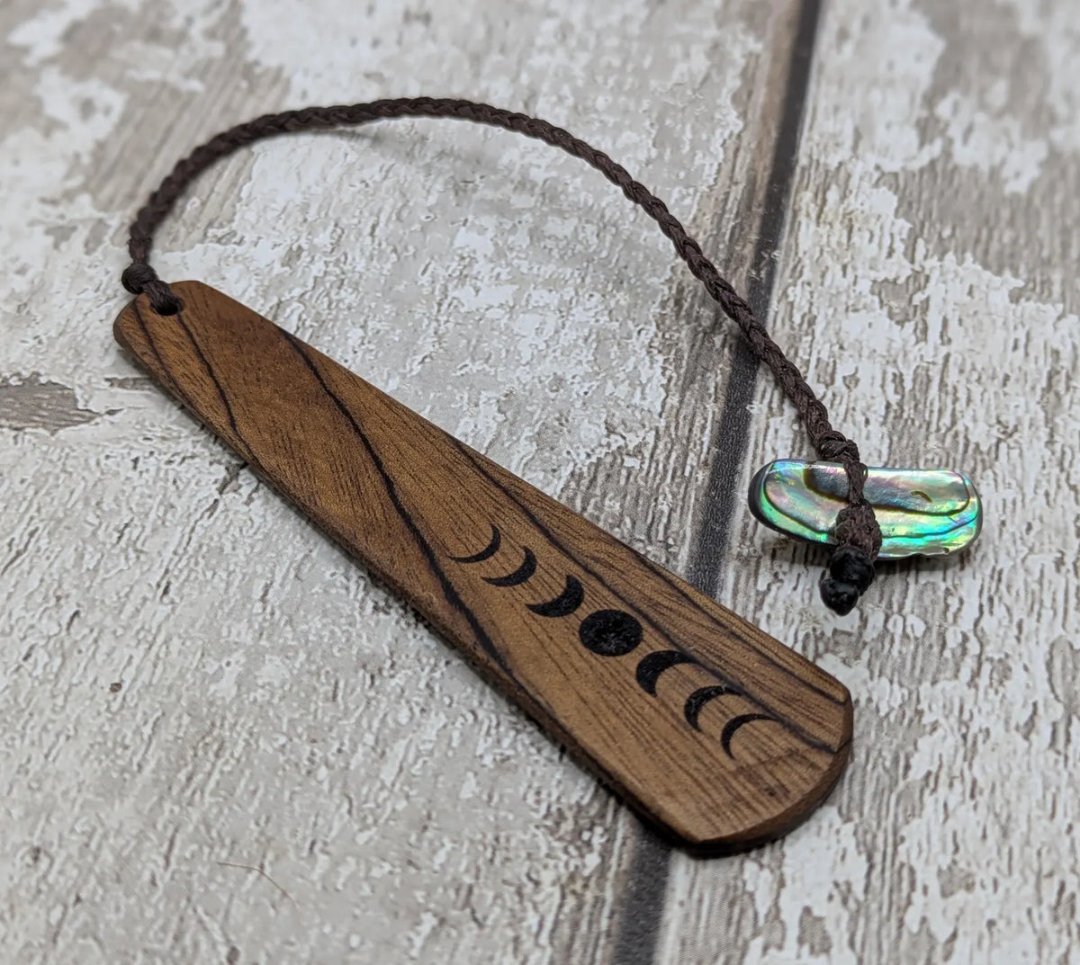 Walnut wood moon phrase laser printed bookmark with pāua abalone shell bead tassel.
