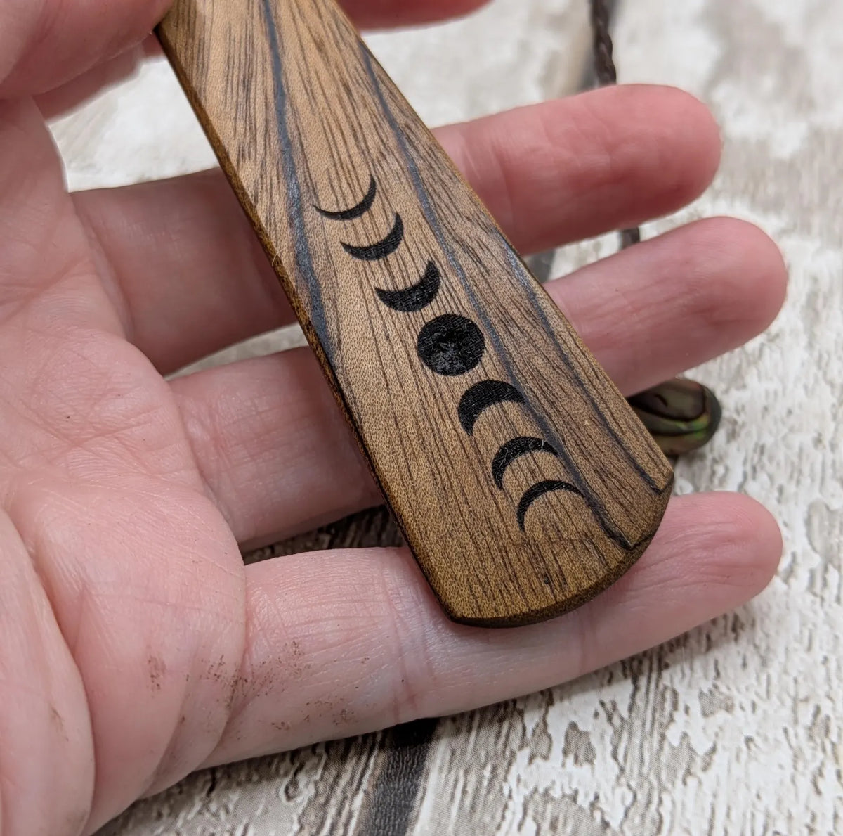 Walnut wood moon phrase laser printed bookmark with pāua abalone shell bead tassel.