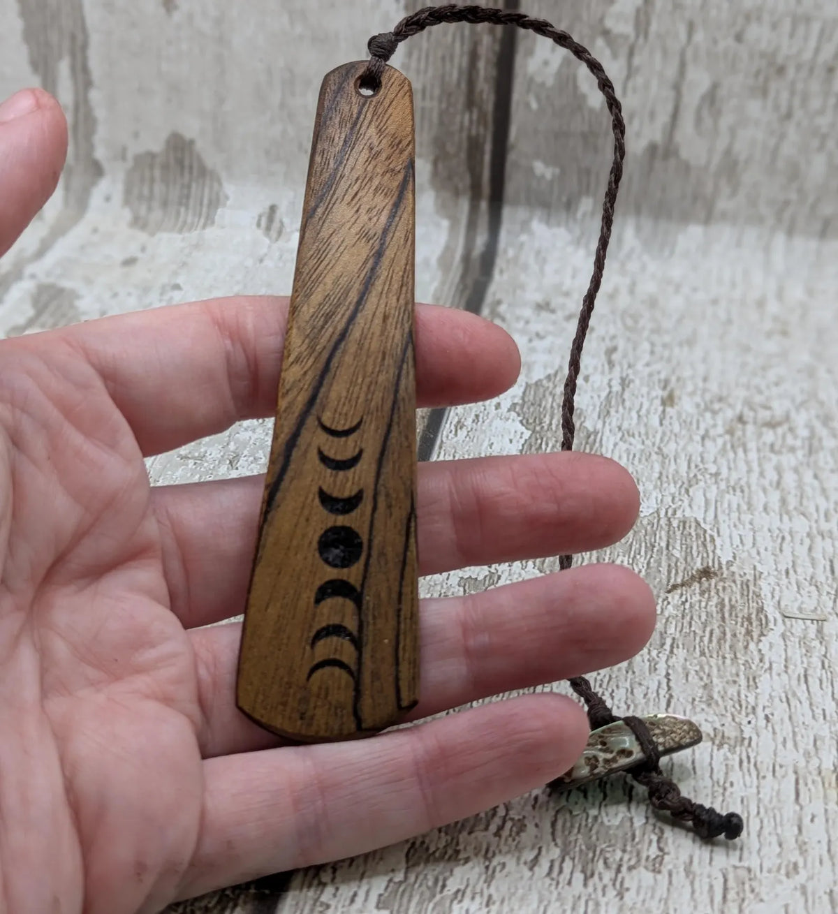 Walnut wood moon phrase laser printed bookmark with pāua abalone shell bead tassel.