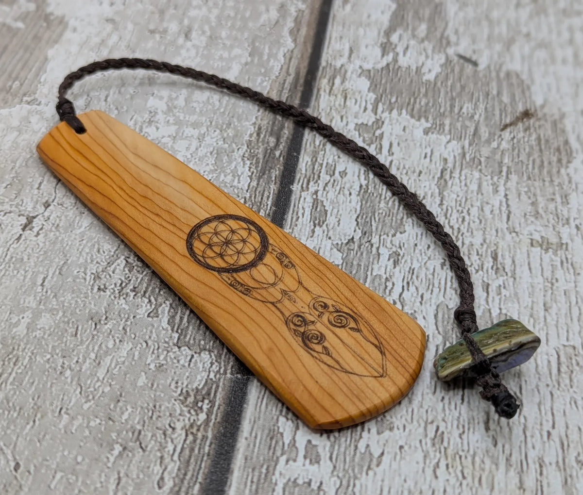 Yew wood, goddess deity laser printed bookmark with pāua shell beaded tassel.