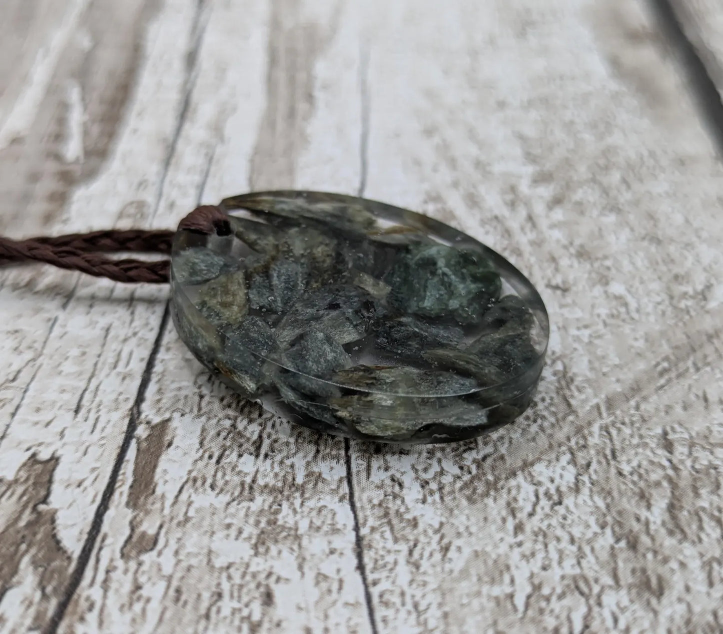 Oval mixed Pounamu jade offcuts in epoxy resin pendant.