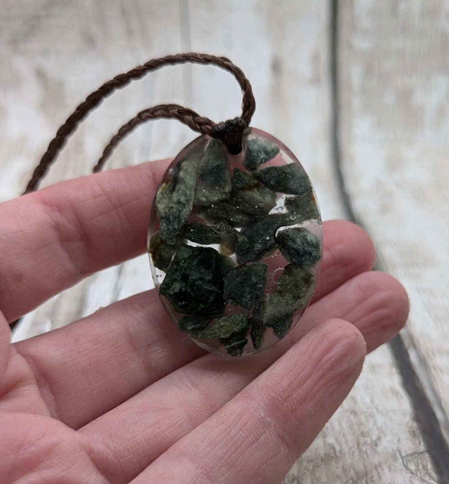 Oval mixed Pounamu jade offcuts in epoxy resin pendant.