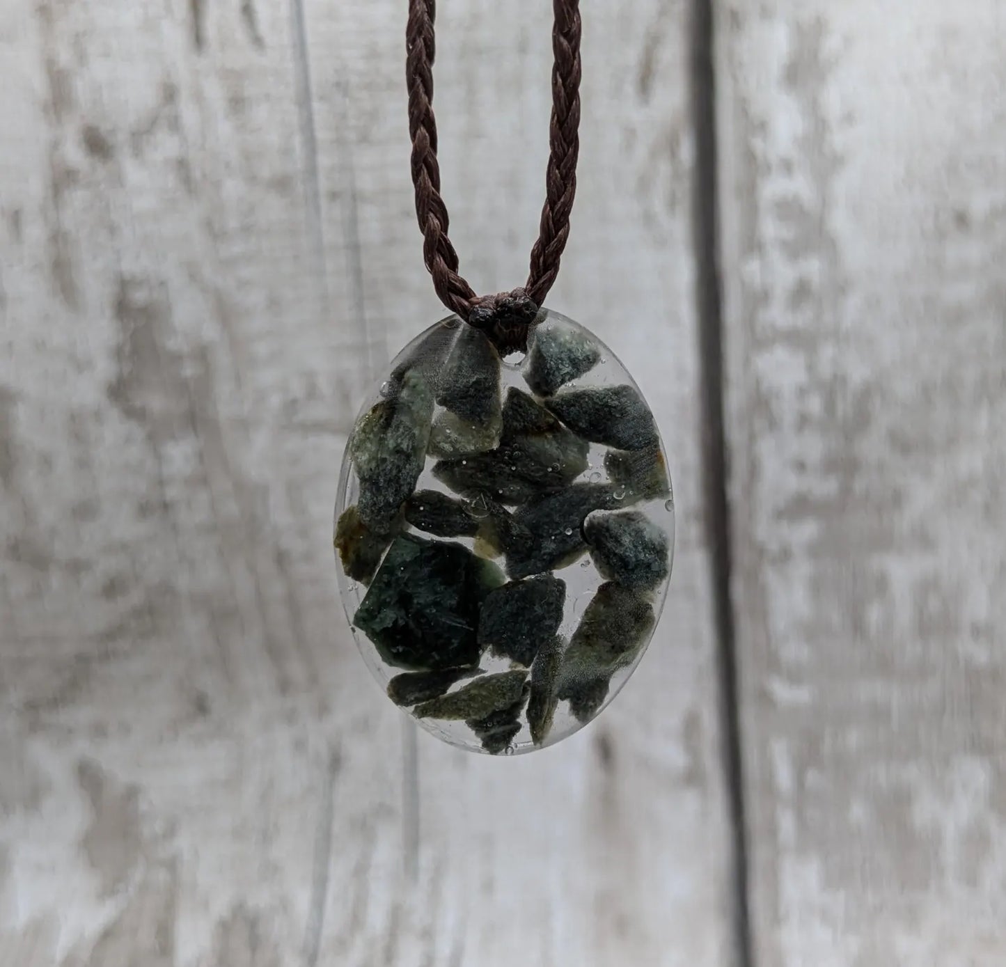 Oval mixed Pounamu jade offcuts in epoxy resin pendant.