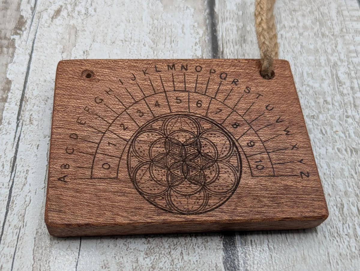 Sepele mahogany pendulum dowsing board with geometric print.