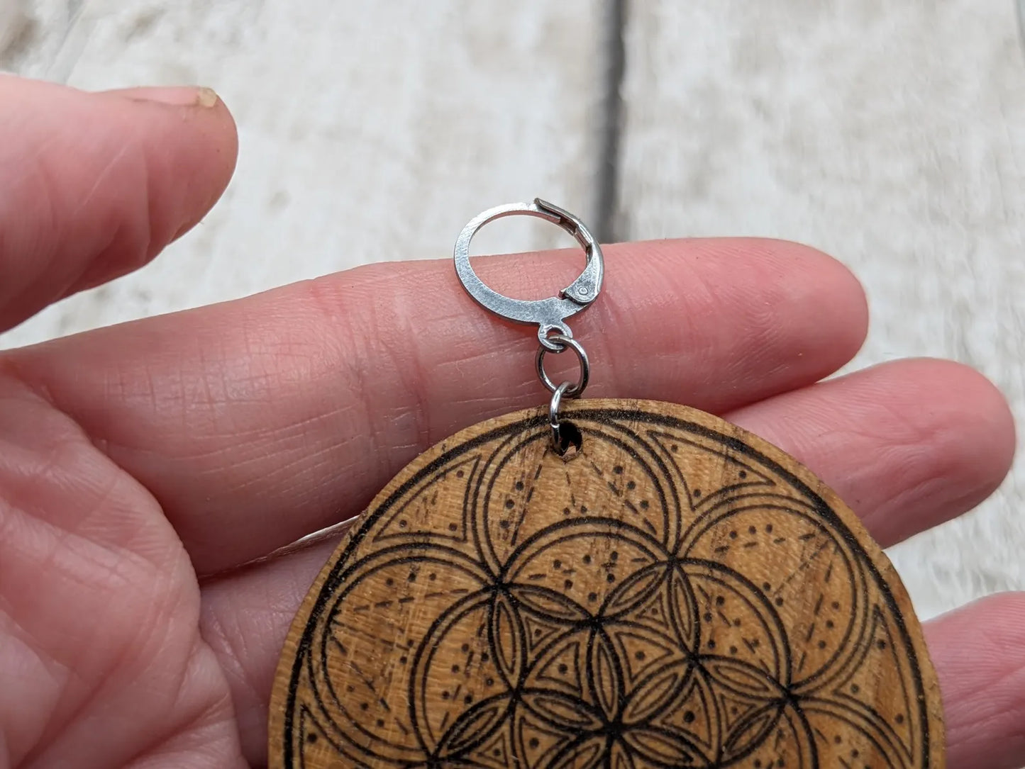 Oak wood disk earrings with laser printed geometric flower of life design, on stainless steel findings.