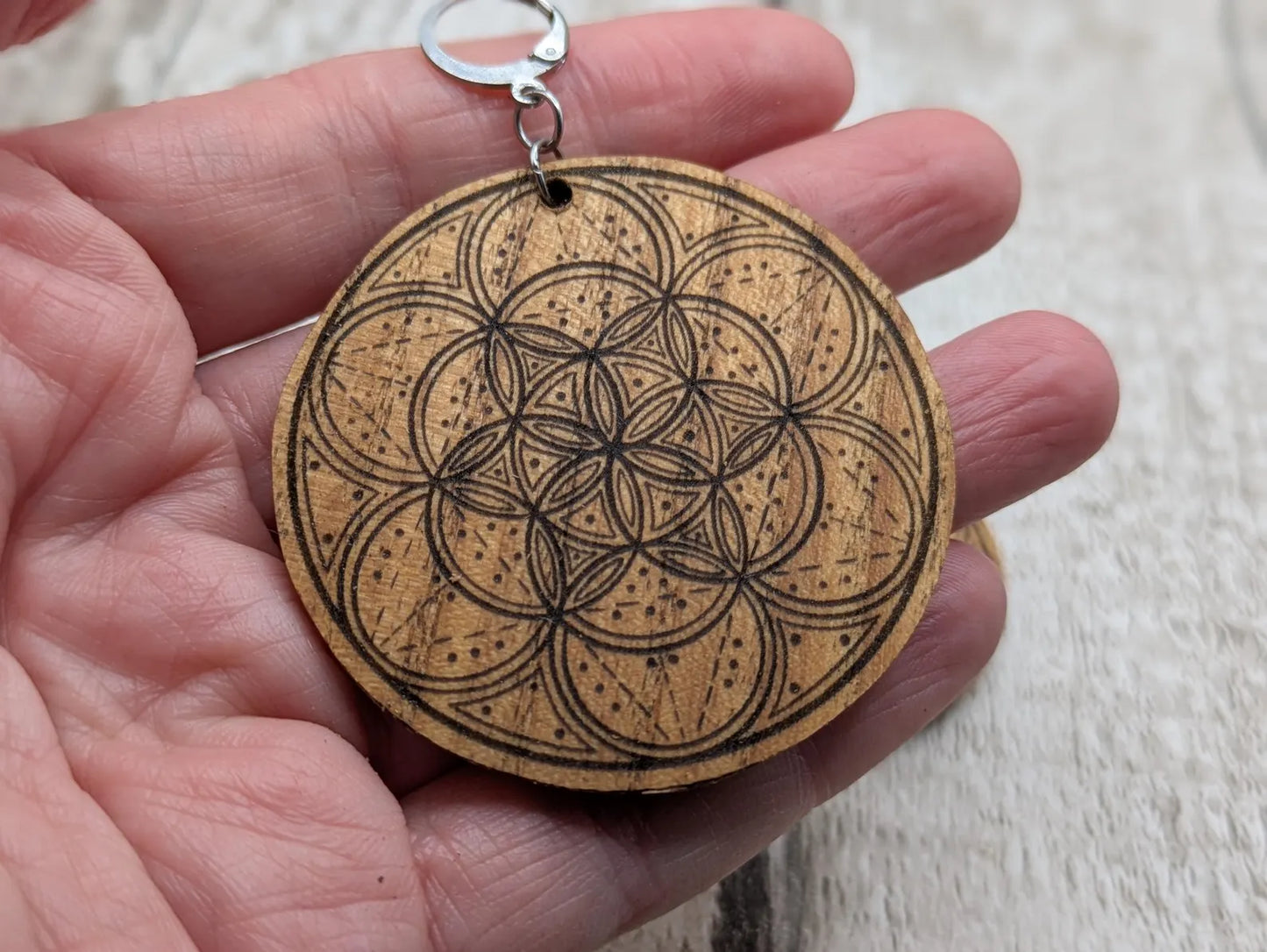 Oak wood disk earrings with laser printed geometric flower of life design, on stainless steel findings.