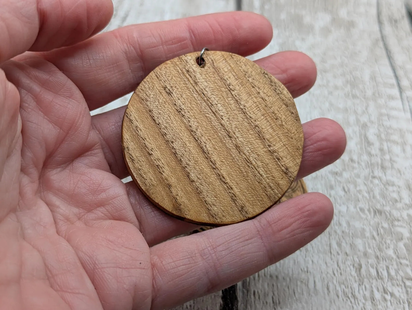 Oak wood disk earrings with laser printed geometric flower of life design, on stainless steel findings.