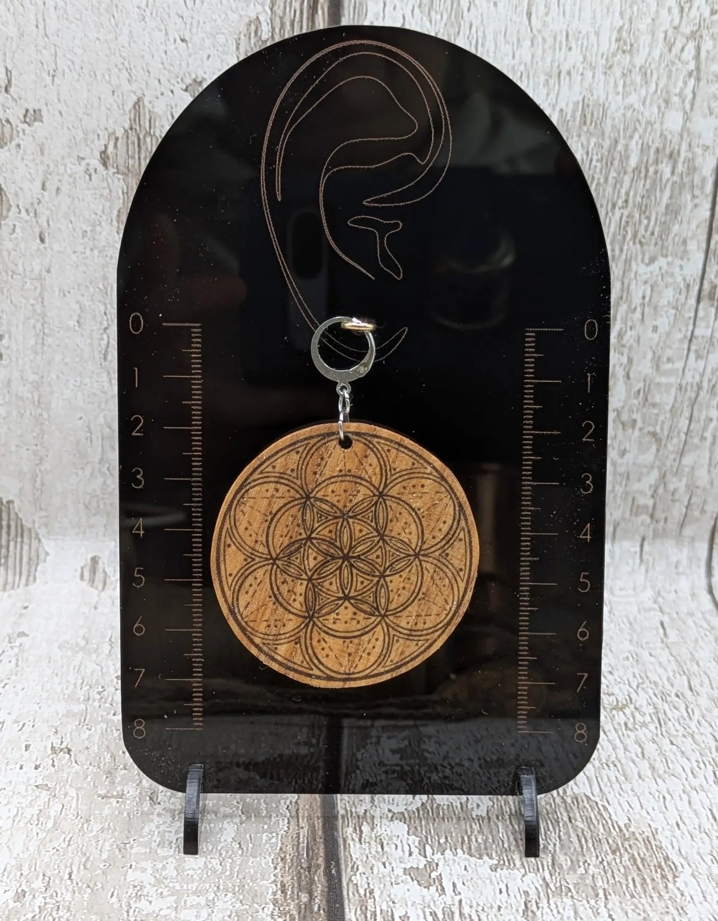 Oak wood disk earrings with laser printed geometric flower of life design, on stainless steel findings.