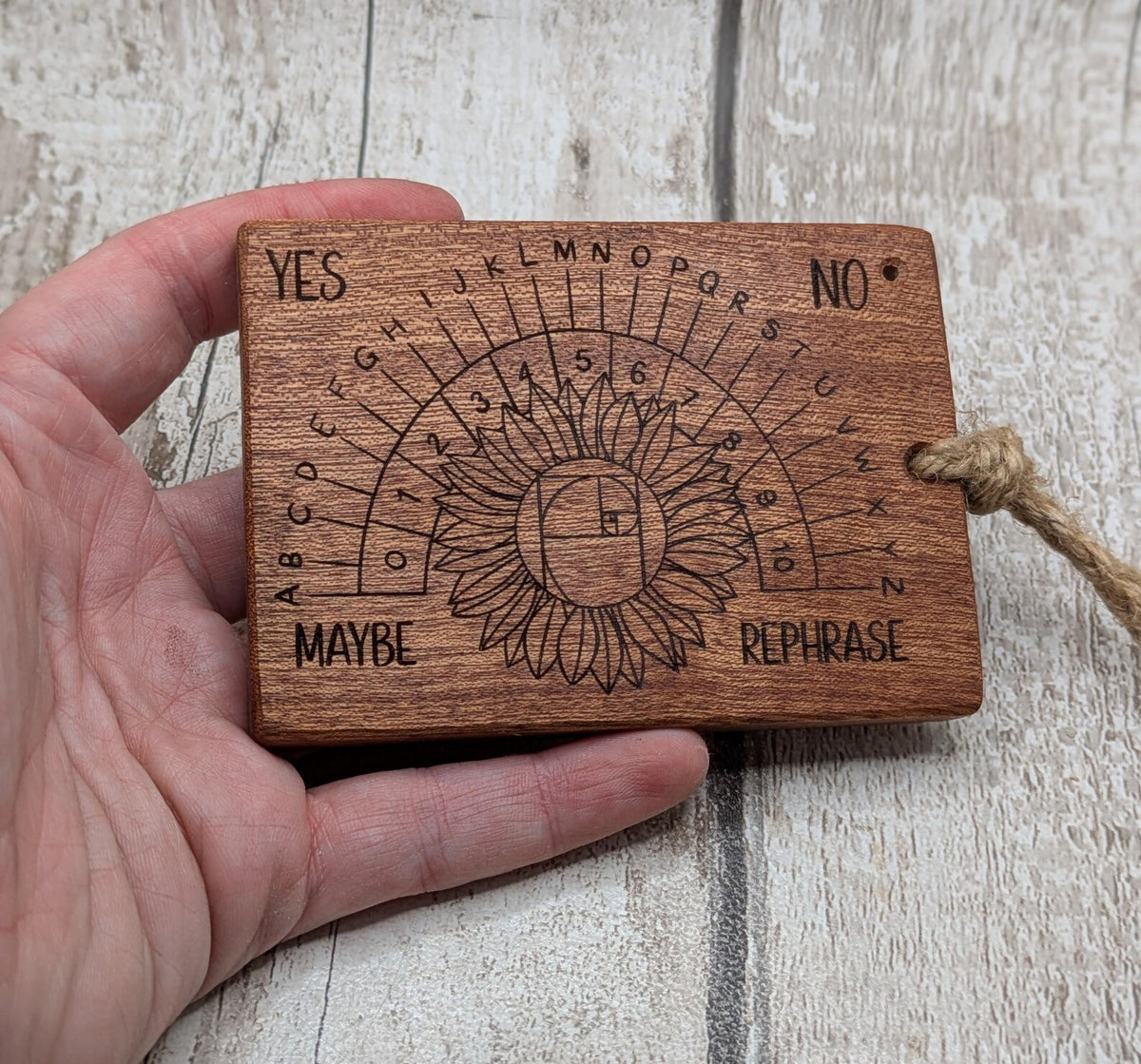 Sepele mahogany pendulum dowsing board with sunflower laser design.