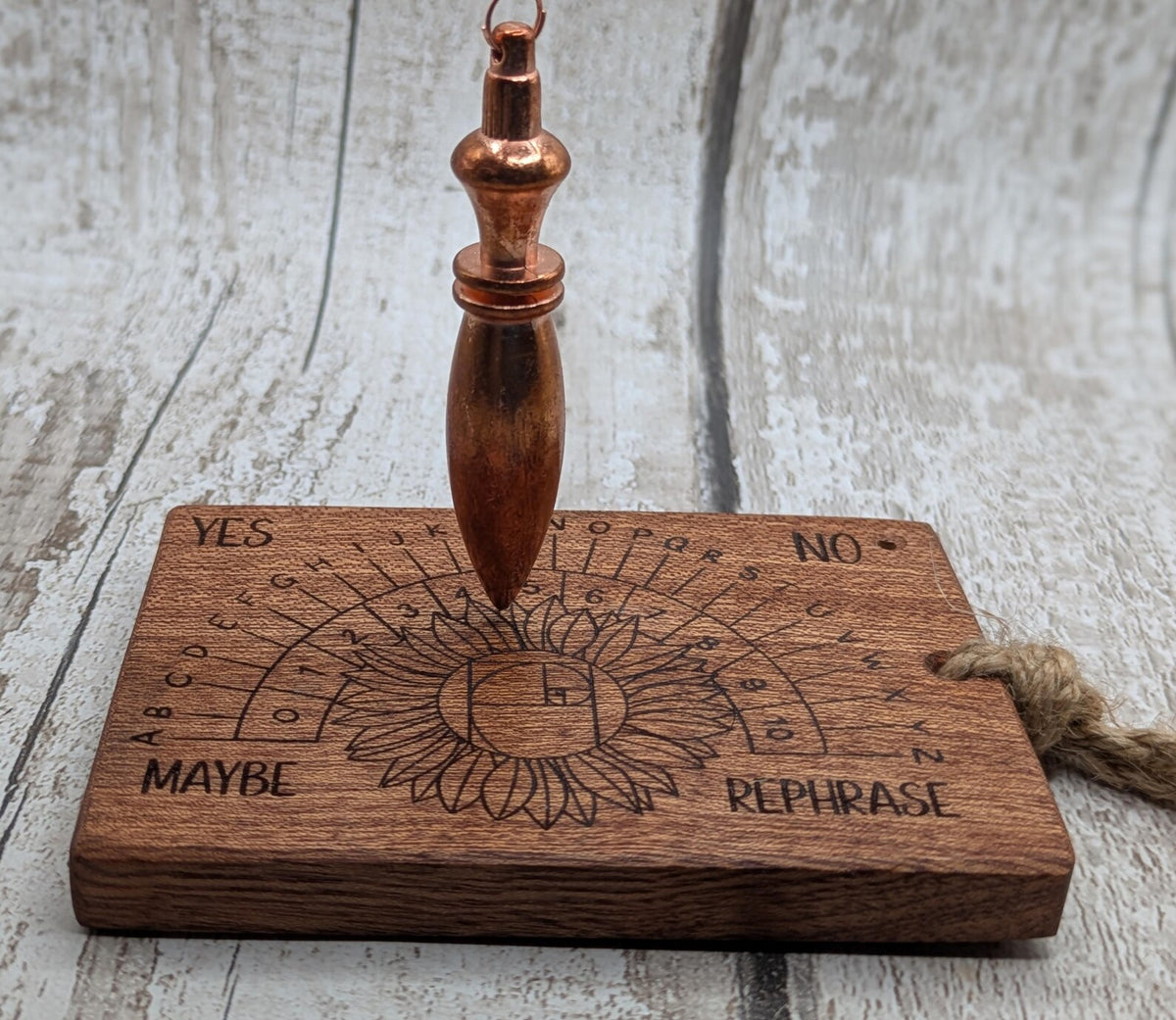Sepele mahogany pendulum dowsing board with sunflower laser design.