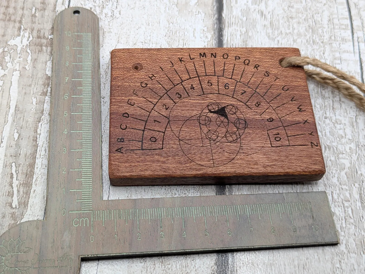 Sepele mahogany pendulum dowsing board with Celtic geometric design.