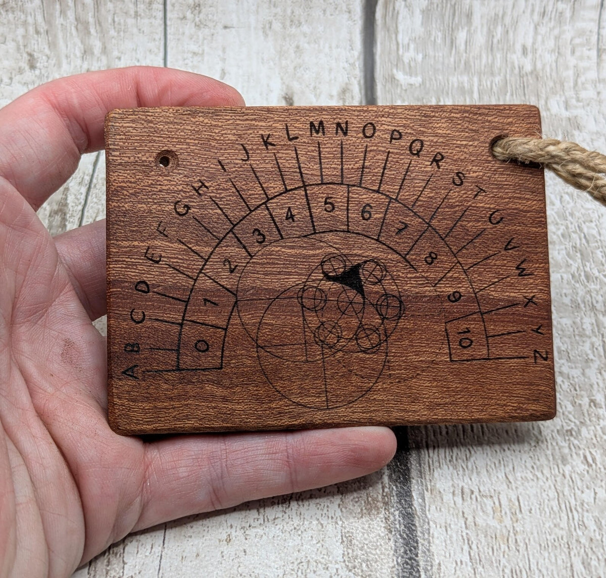 Sepele mahogany pendulum dowsing board with Celtic geometric design.