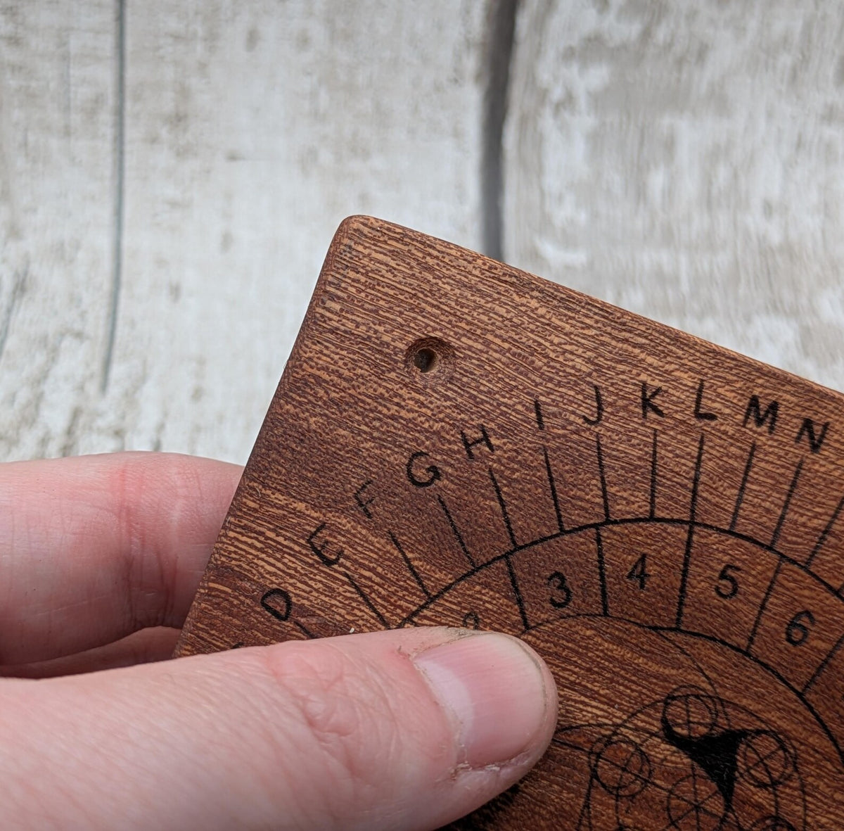 Sepele mahogany pendulum dowsing board with Celtic geometric design.