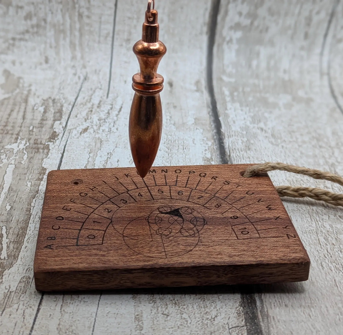 Sepele mahogany pendulum dowsing board with Celtic geometric design.