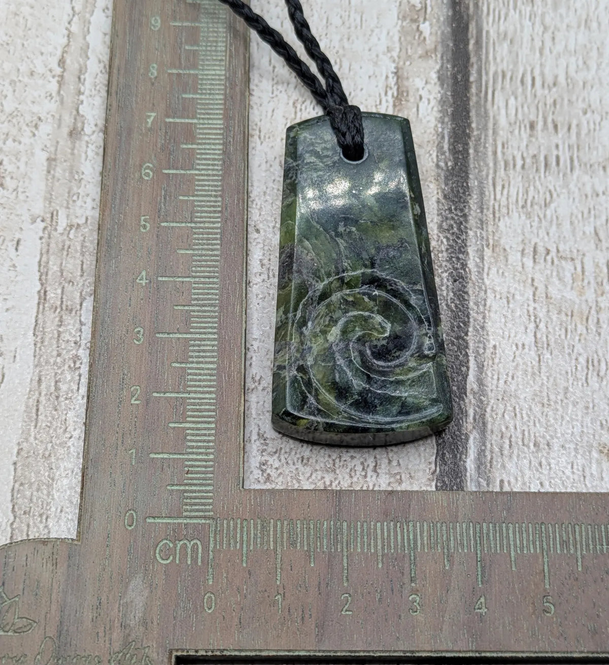 New Zealand Haast pass Douglas creek serpentine pounamu pendant with koru design.