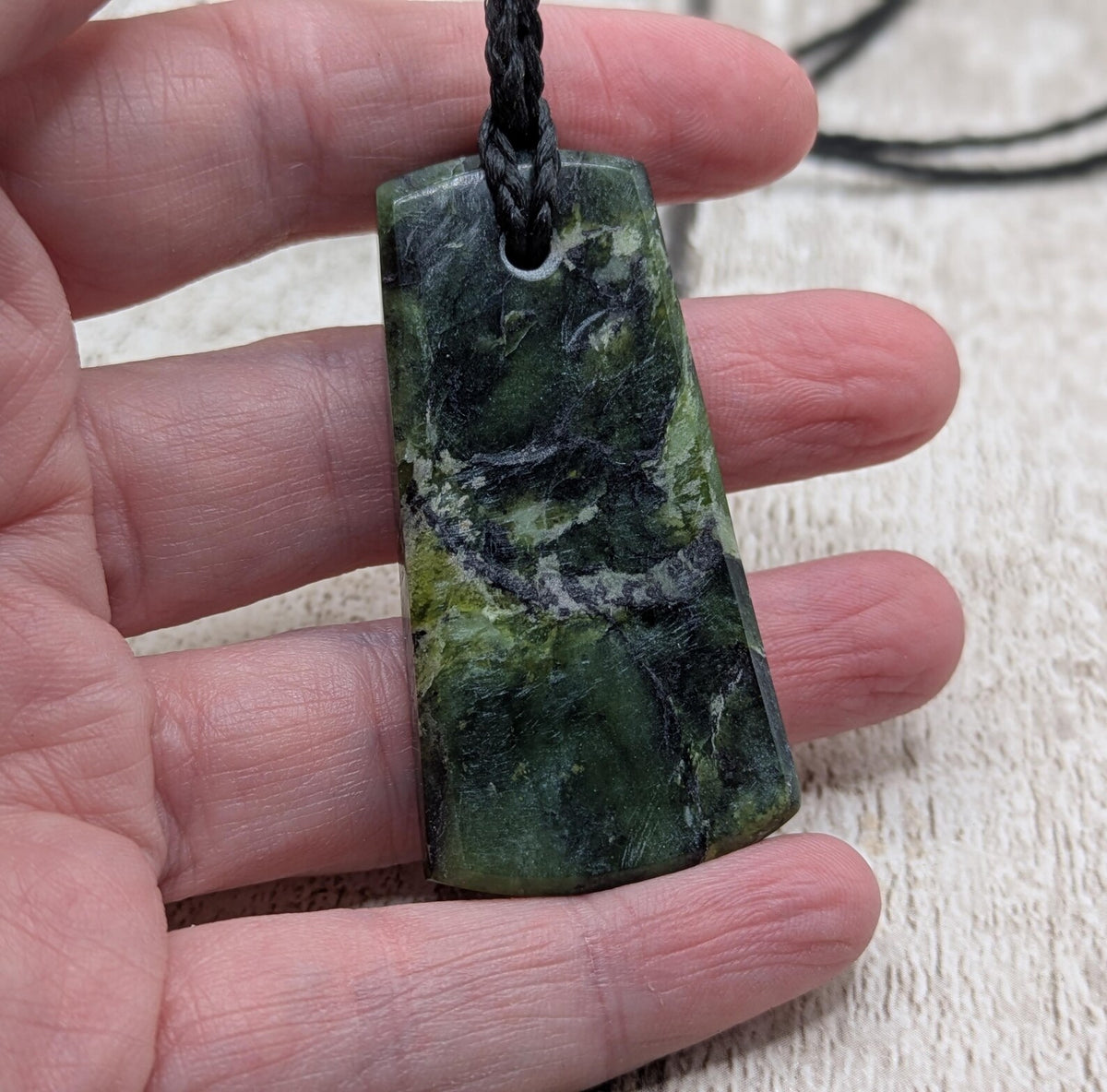 New Zealand Haast pass Douglas creek serpentine pounamu pendant with koru design.