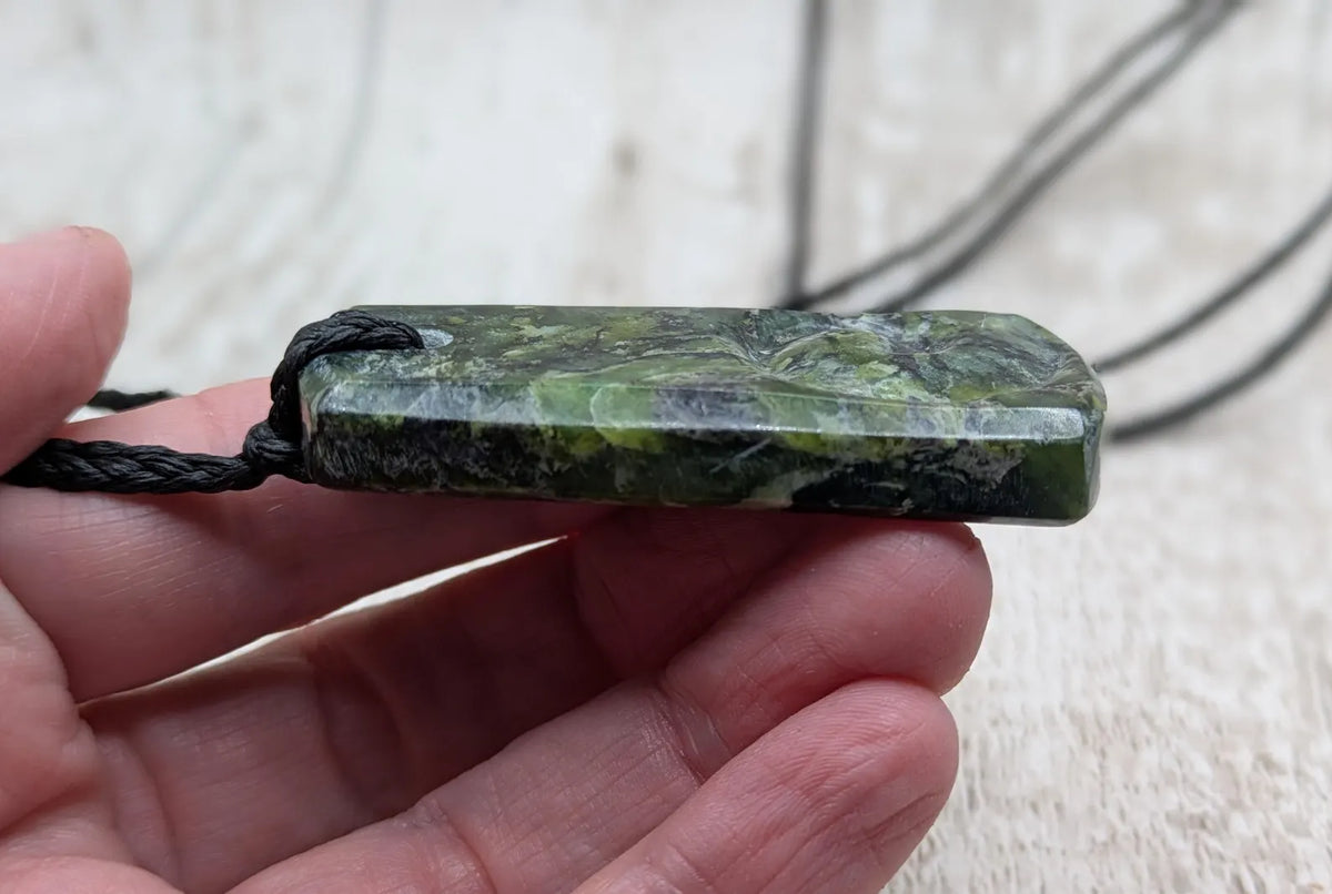 New Zealand Haast pass Douglas creek serpentine pounamu pendant with koru design.