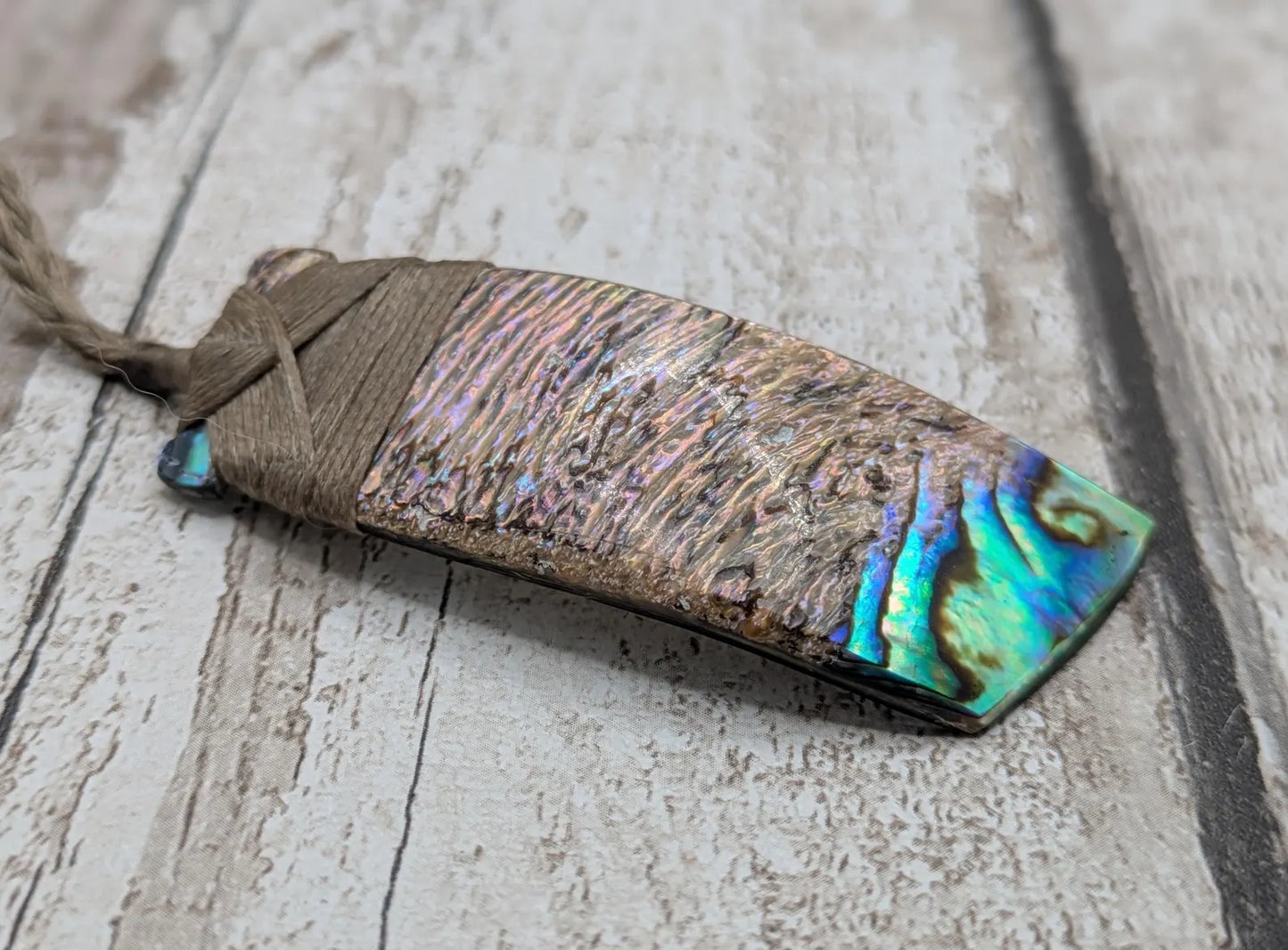 Wild New Zealand rainbow Pāua Hei toki adze pendant.