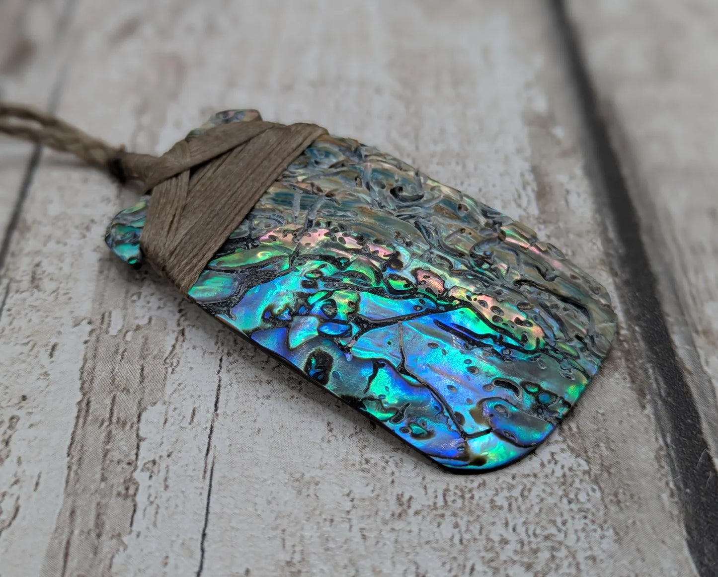 Wild New Zealand rainbow Pāua Hei Toki adze pendant.