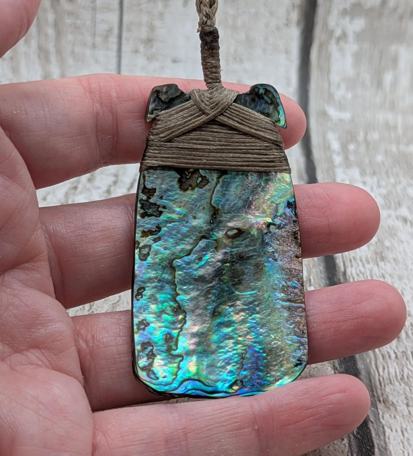 Wild New Zealand rainbow Pāua Hei Toki adze pendant.