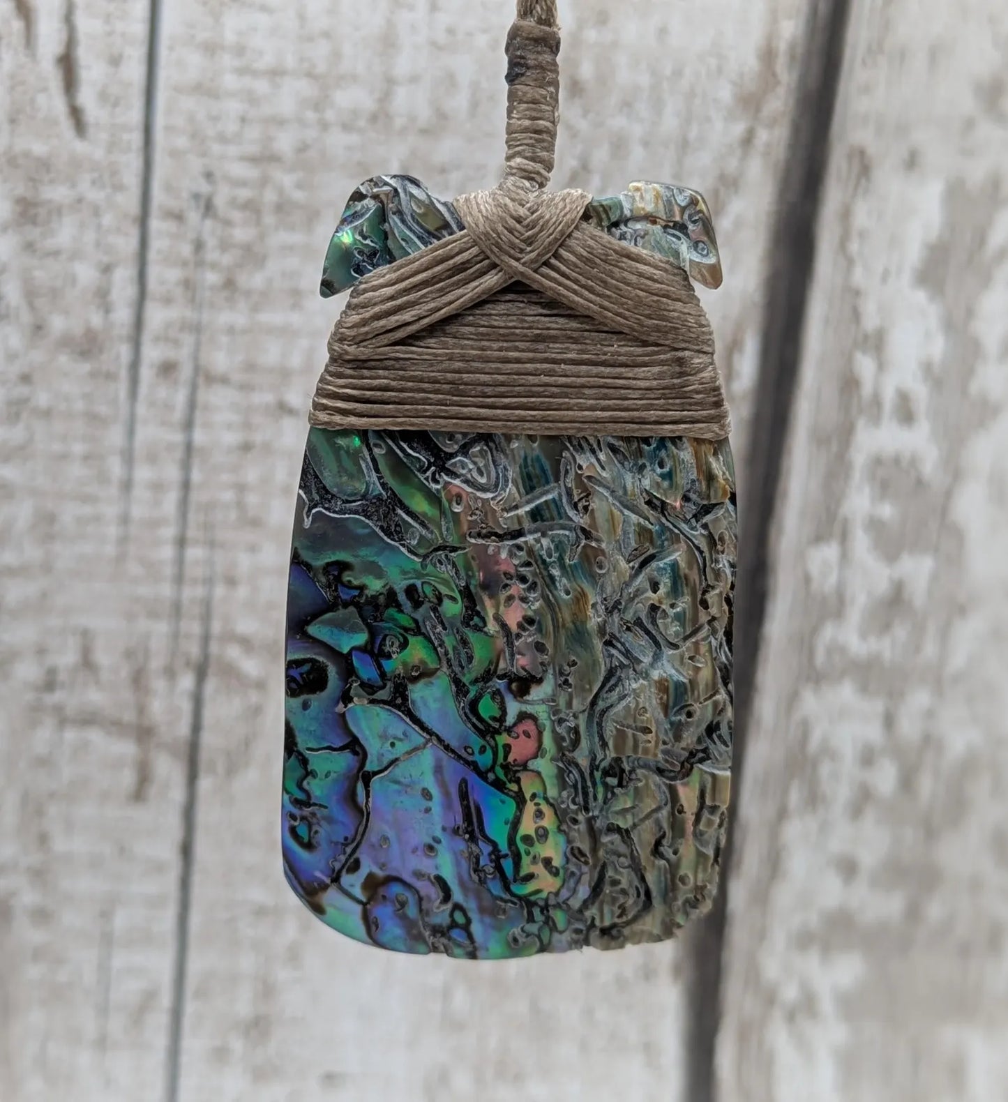 Wild New Zealand rainbow Pāua Hei Toki adze pendant.