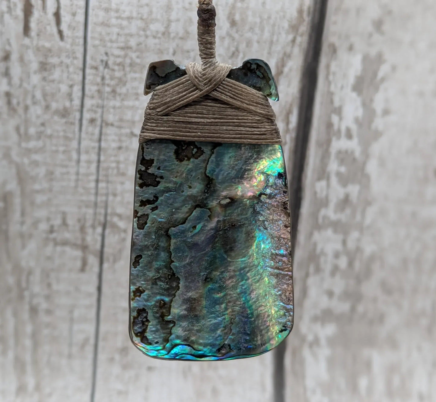 Wild New Zealand rainbow Pāua Hei Toki adze pendant.