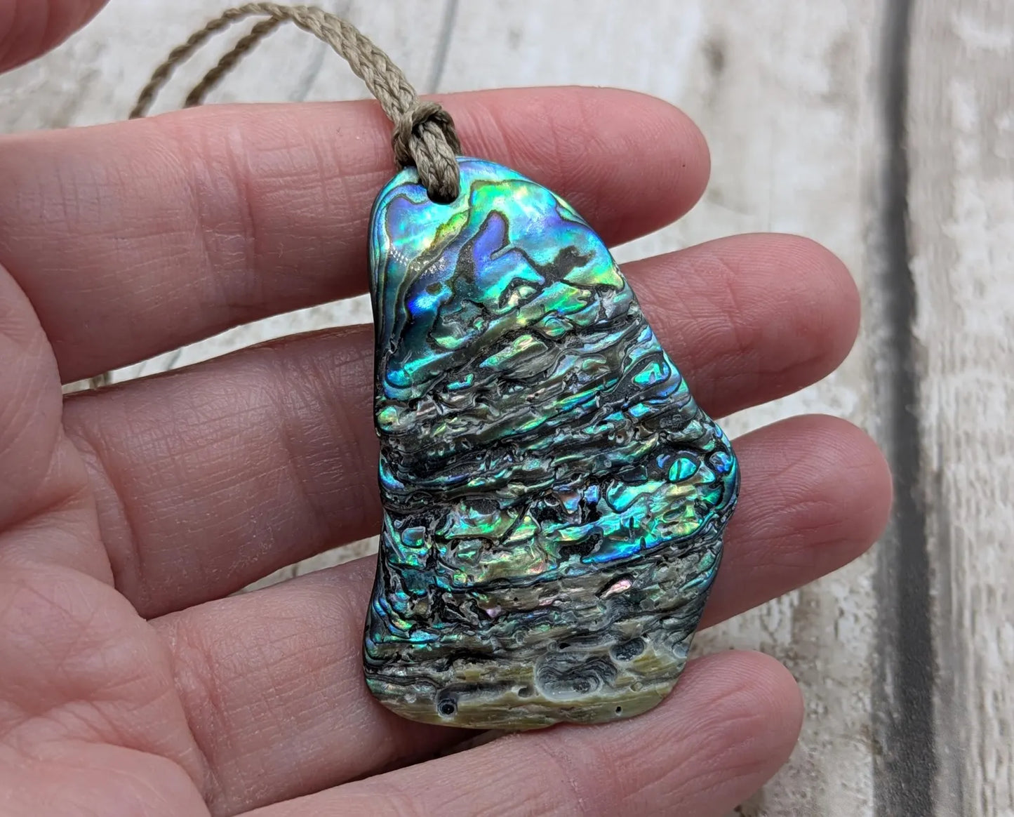New Zealand free form naturally tumbled Pāua shell pendant.