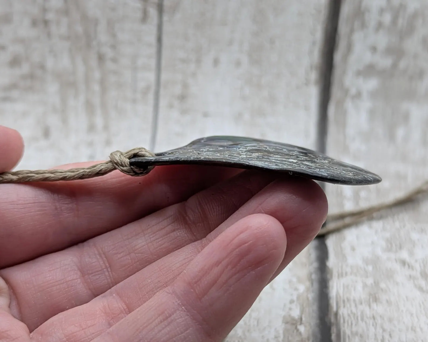 Free form naturally tumbled New Zealand rainbow Pāua pendant.