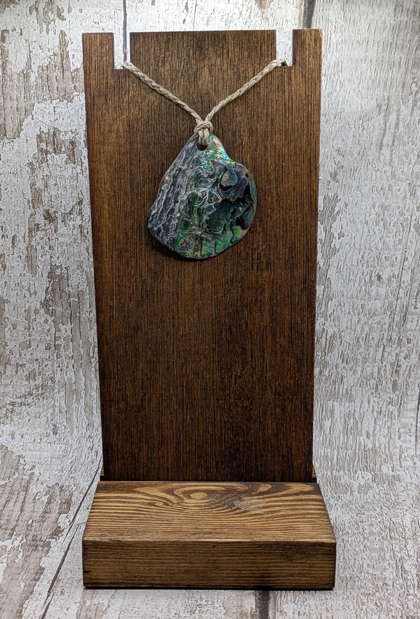 Free form naturally tumbled New Zealand rainbow Pāua pendant.
