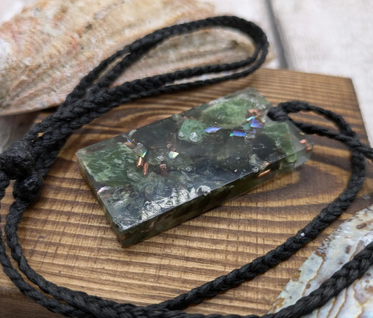 Mixed nephrite jade and copper in resin pendant.