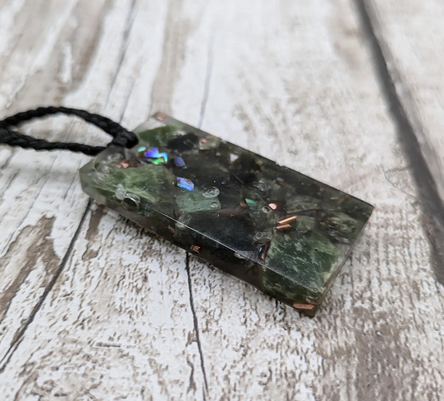 Mixed nephrite jade and copper in resin pendant.