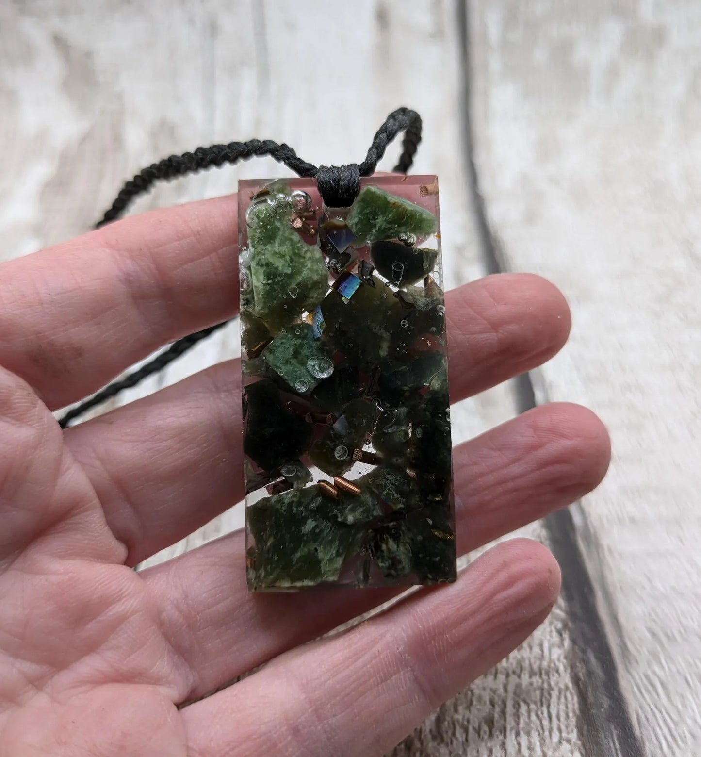 Mixed nephrite jade and copper in resin pendant.